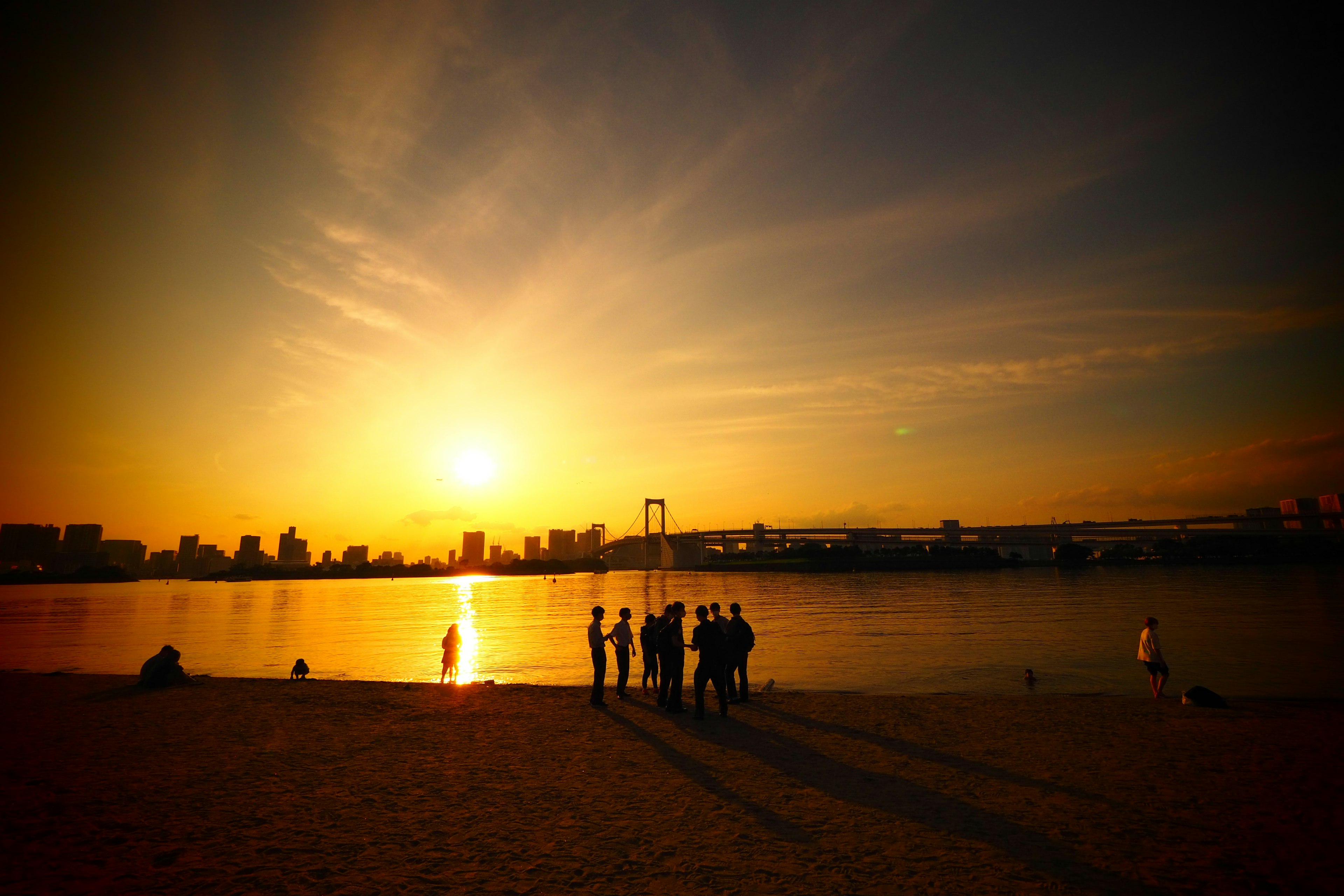 Silhouette von Personen bei Sonnenuntergang mit Stadtansicht