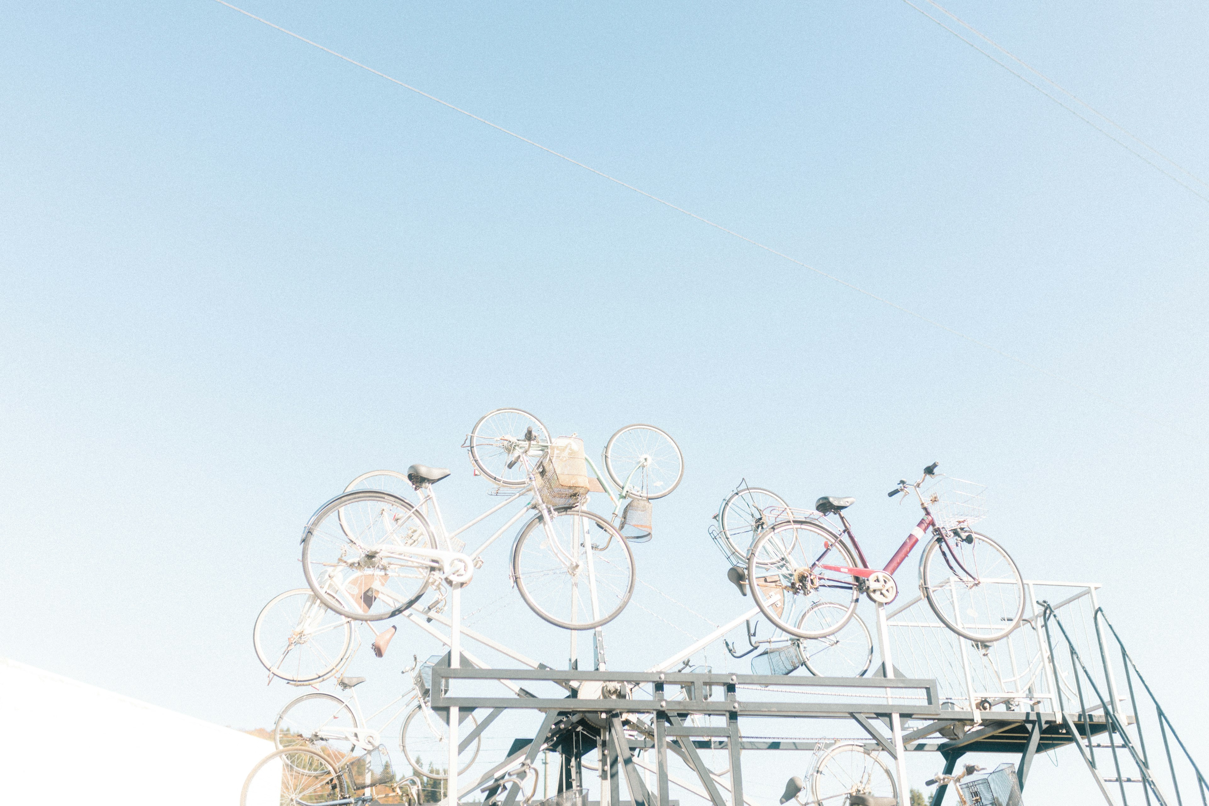 Installazione artistica con ruote di bicicletta sotto un cielo blu chiaro