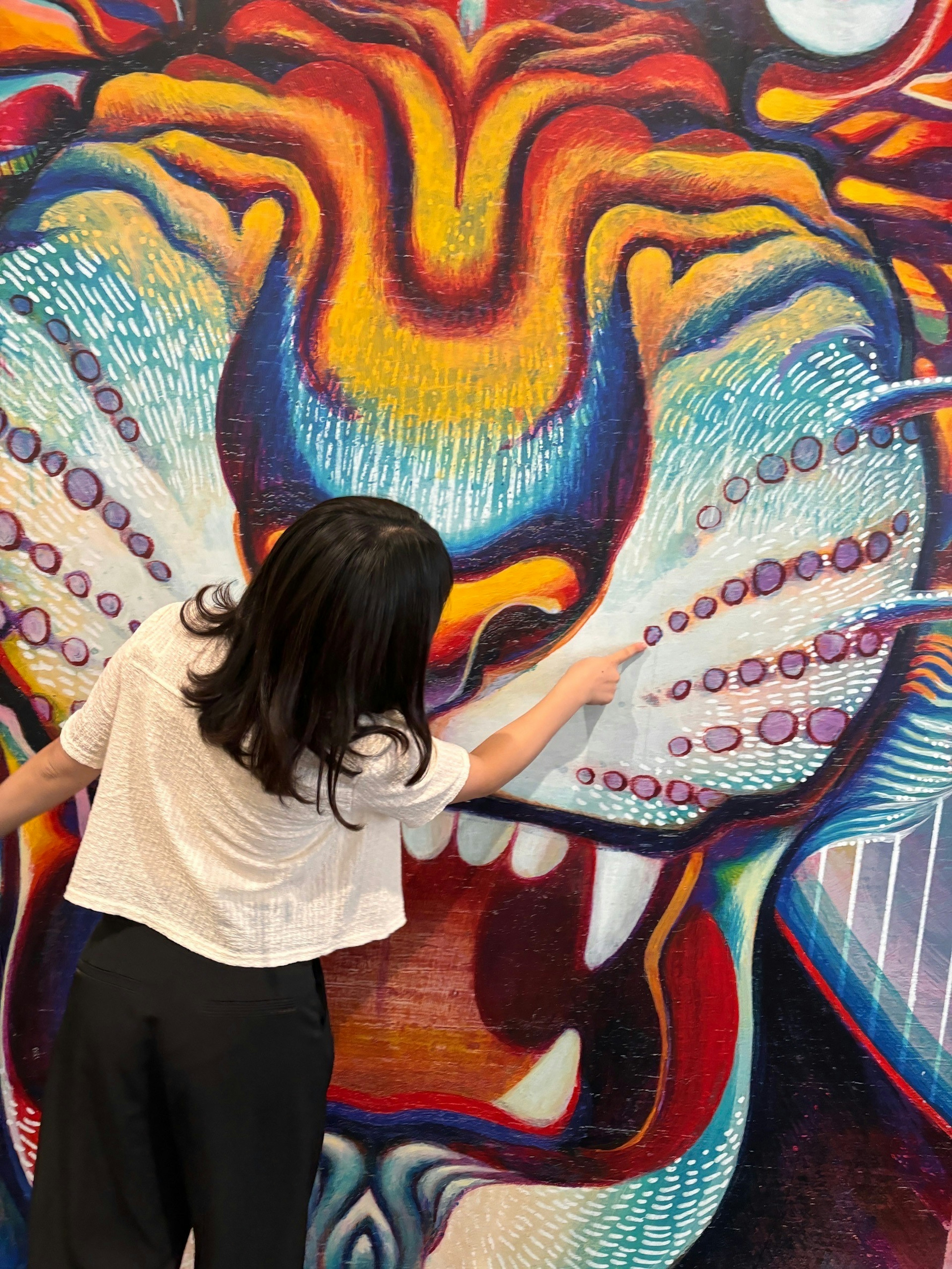 Mujer interactuando con un vibrante mural de león