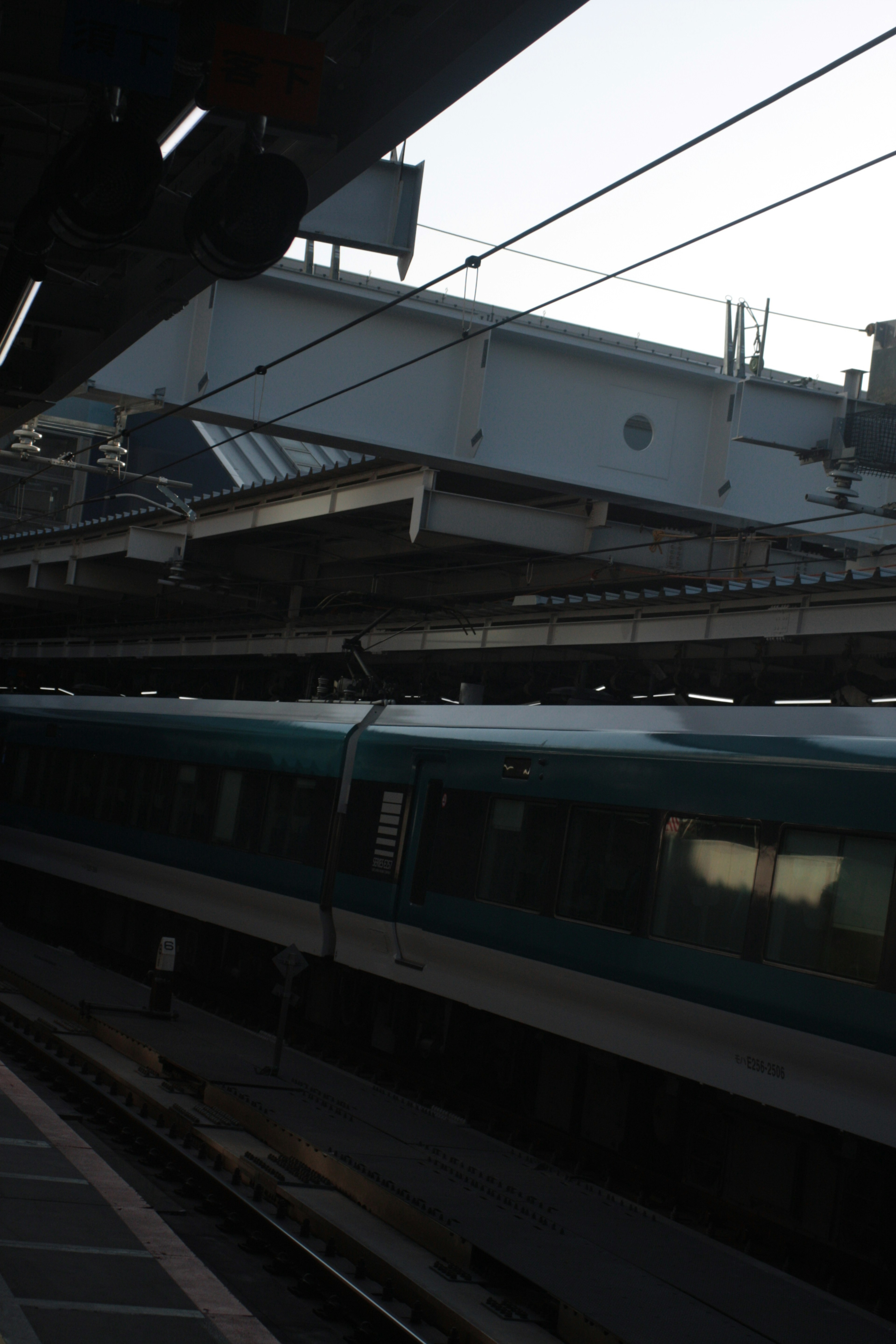 Train at a station platform with overhead structures