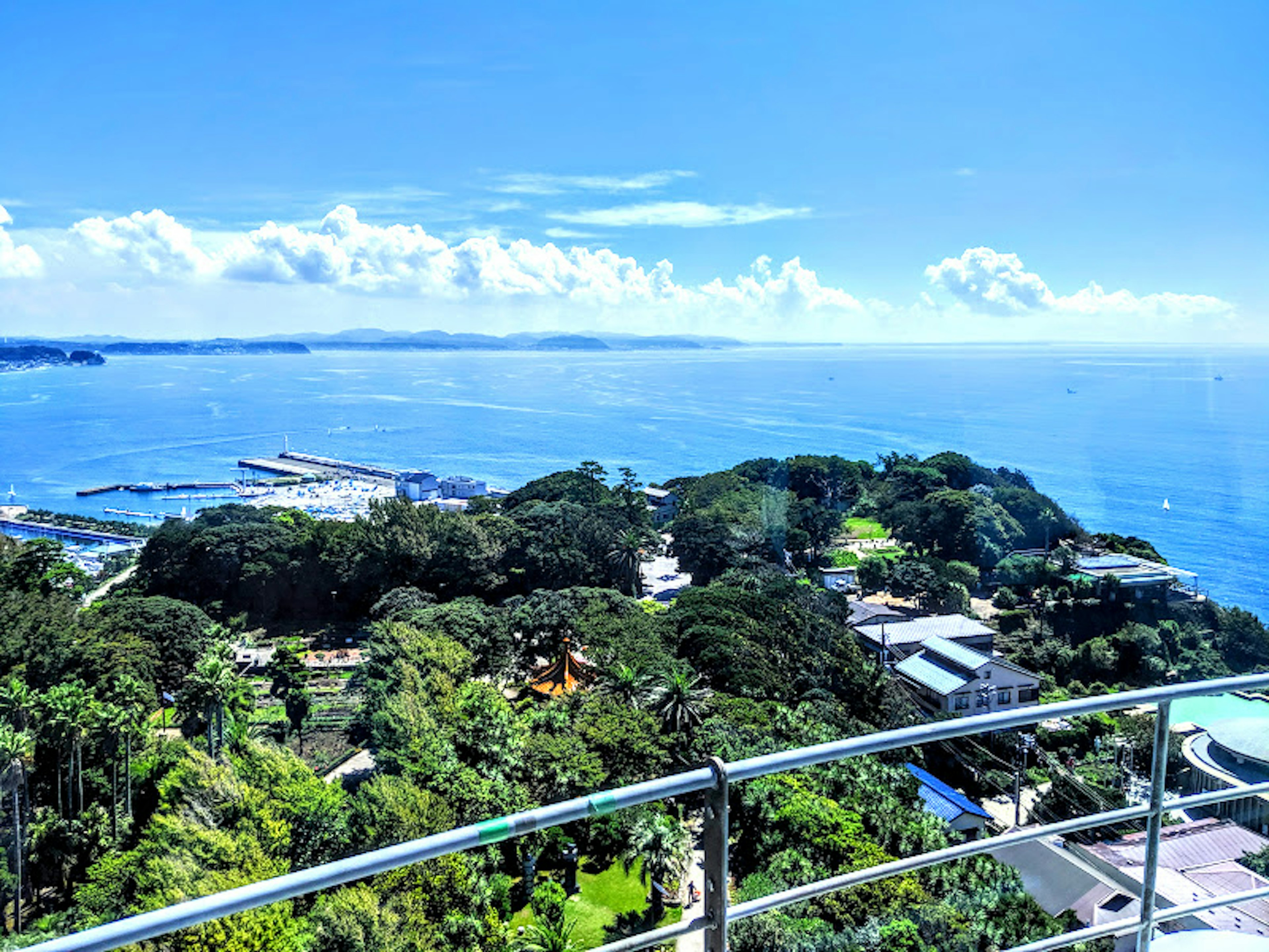 Beautiful view of the blue ocean and sky with a lush island and nearby harbor