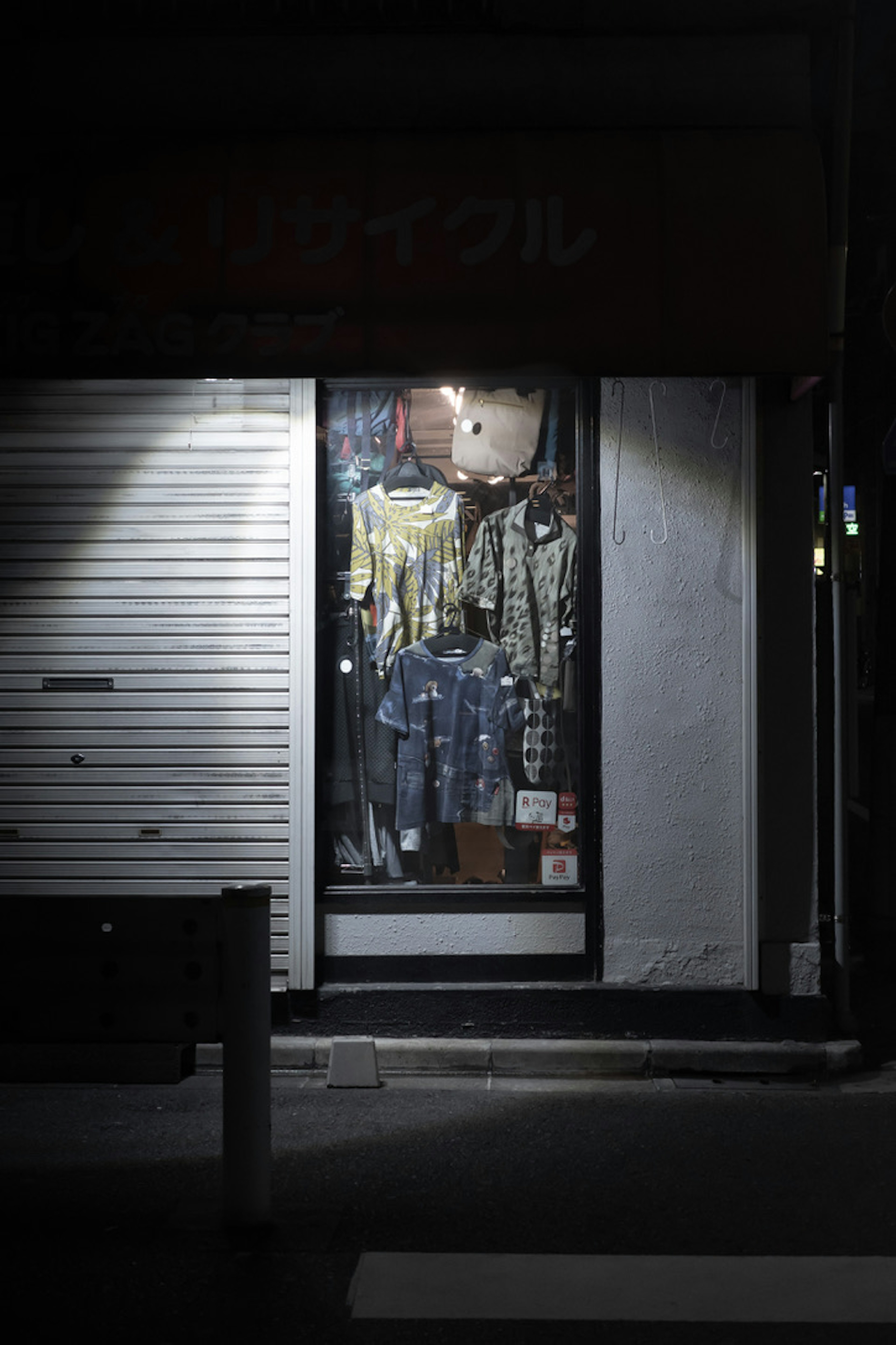 Vêtements et marchandises exposés dans une vitrine de magasin la nuit