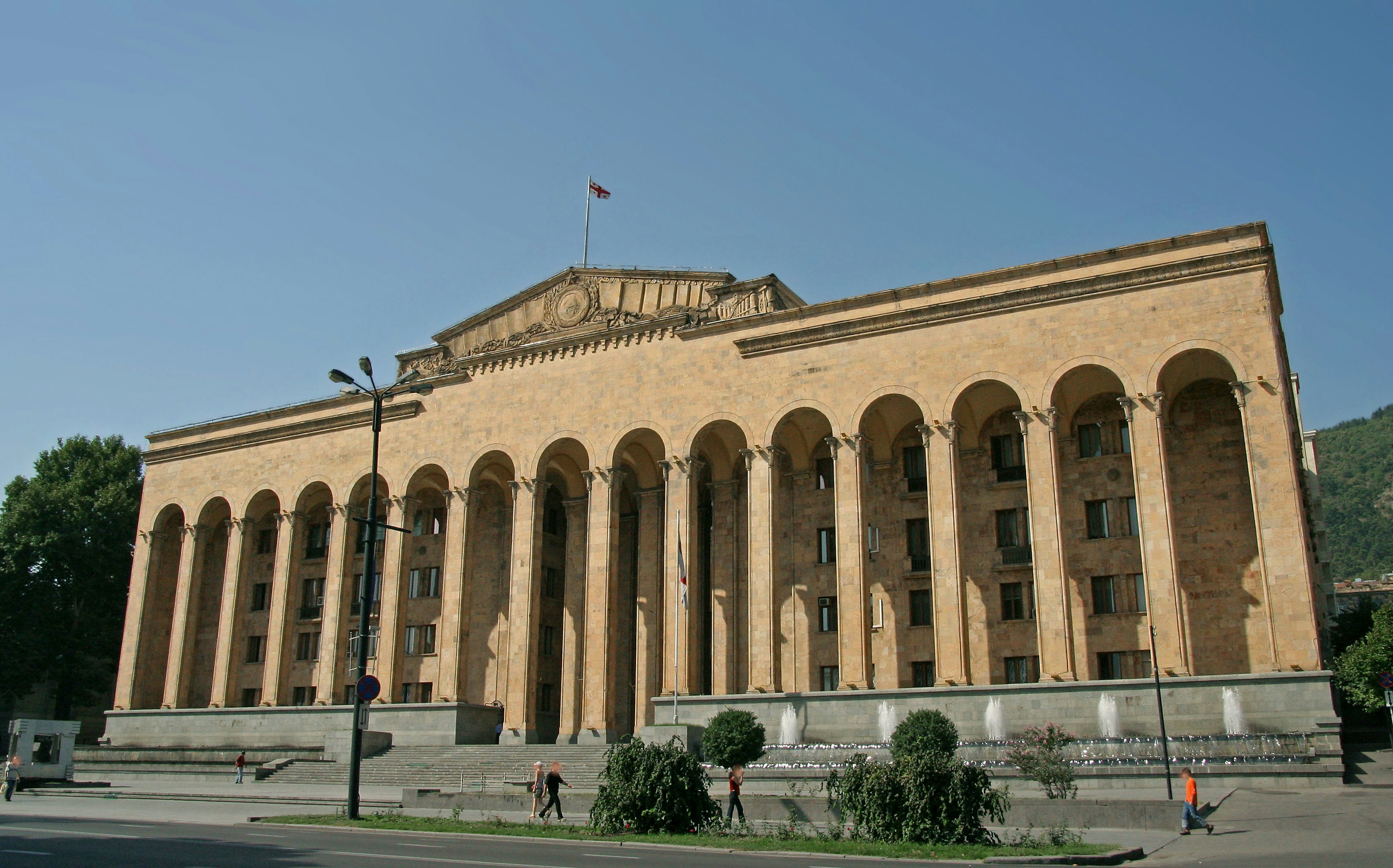 Exterior del edificio del Parlamento georgiano con grandes columnas corintias y una fachada de ladrillo brillante