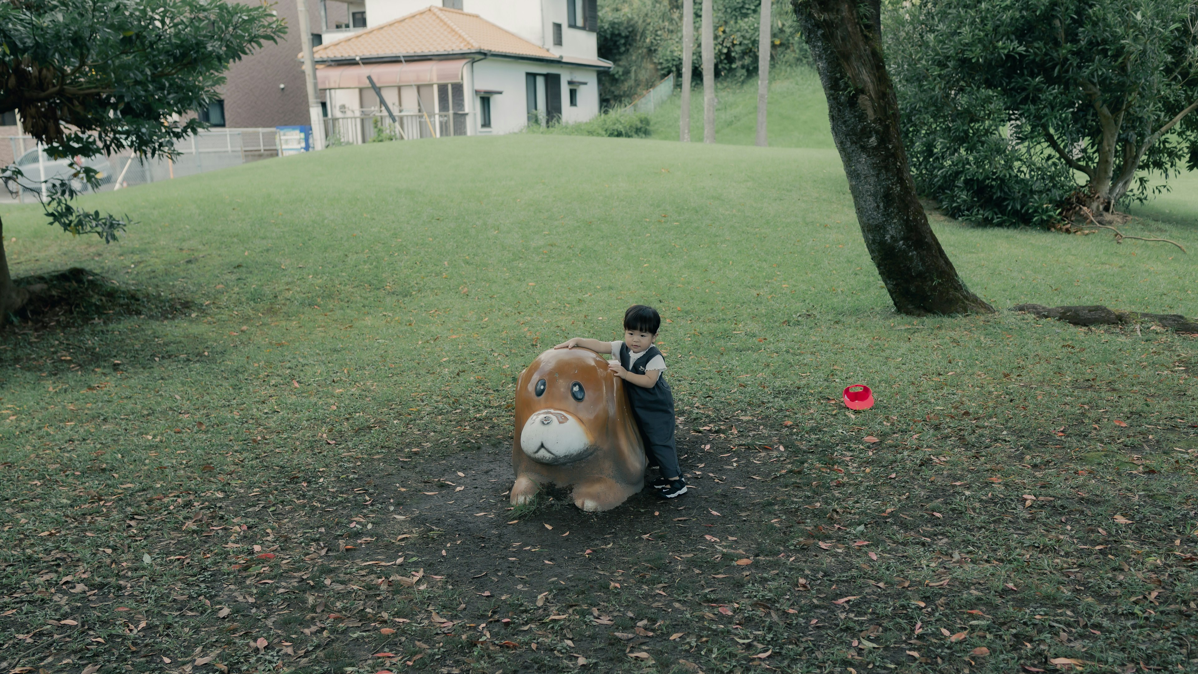 Niño sentado en un juguete de león en un parque