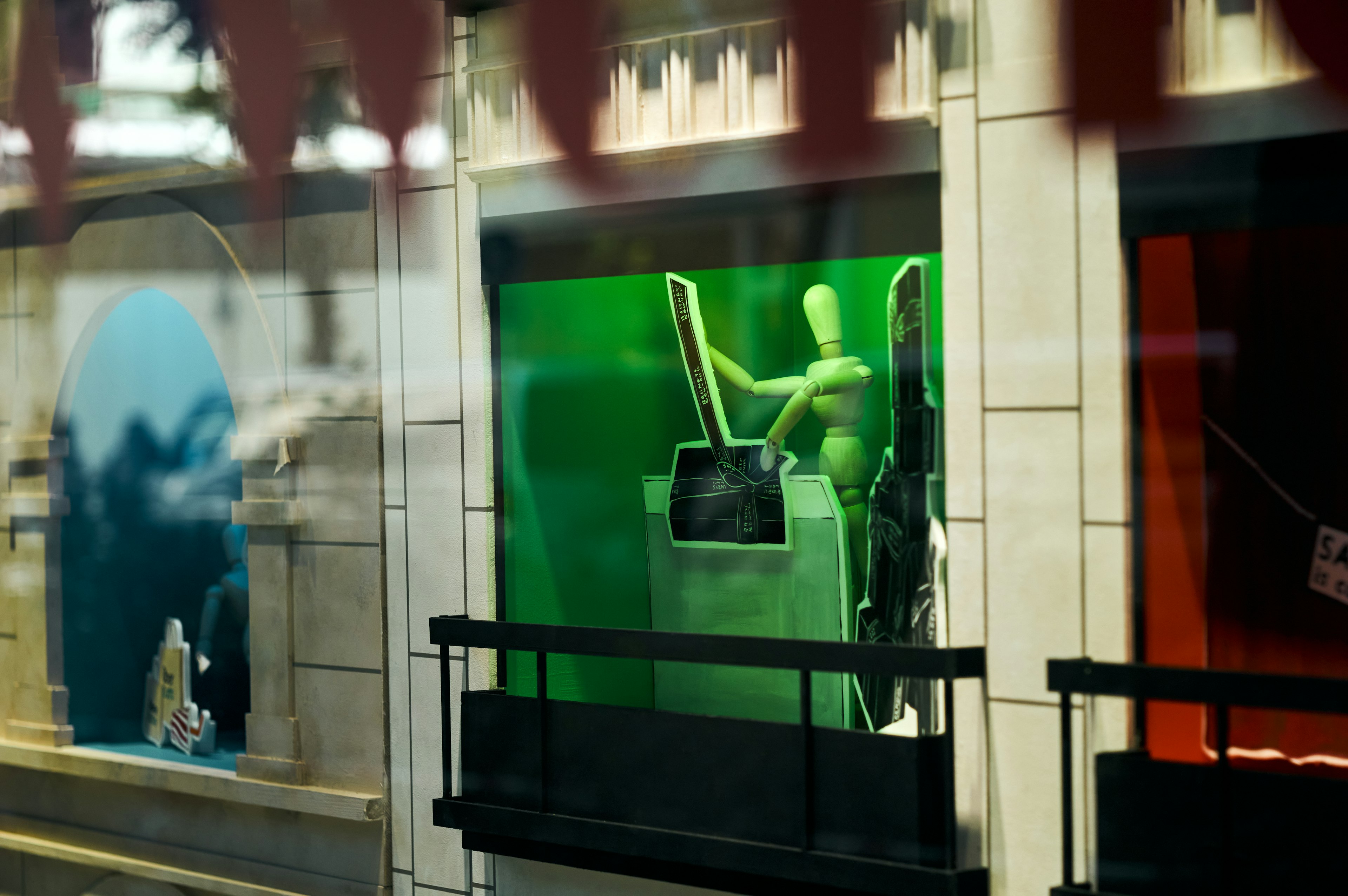 Vitrine présentant un mannequin utilisant un ordinateur sur fond vert