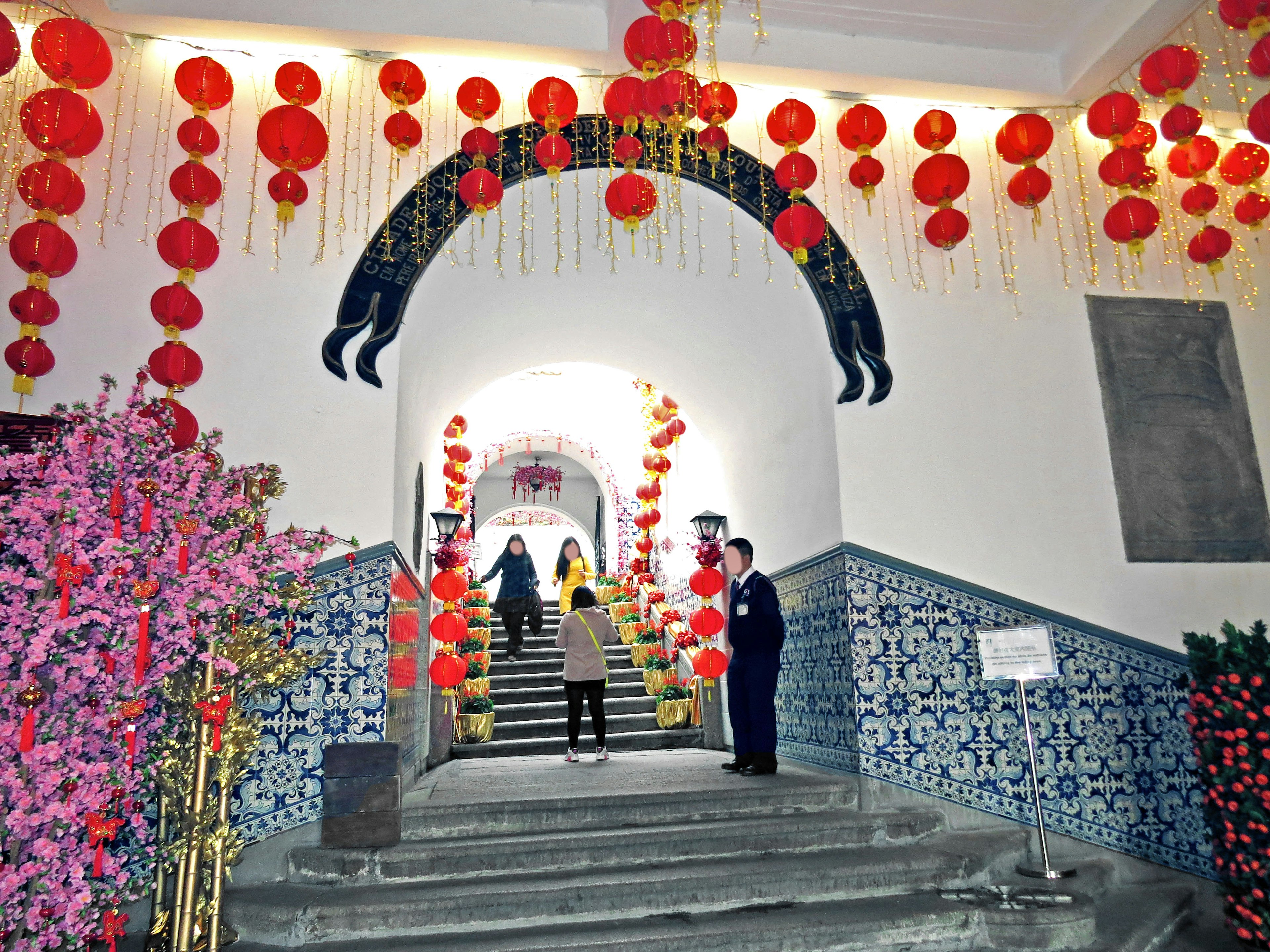 Interior de un edificio chino tradicional con linternas rojas y escalera decorada