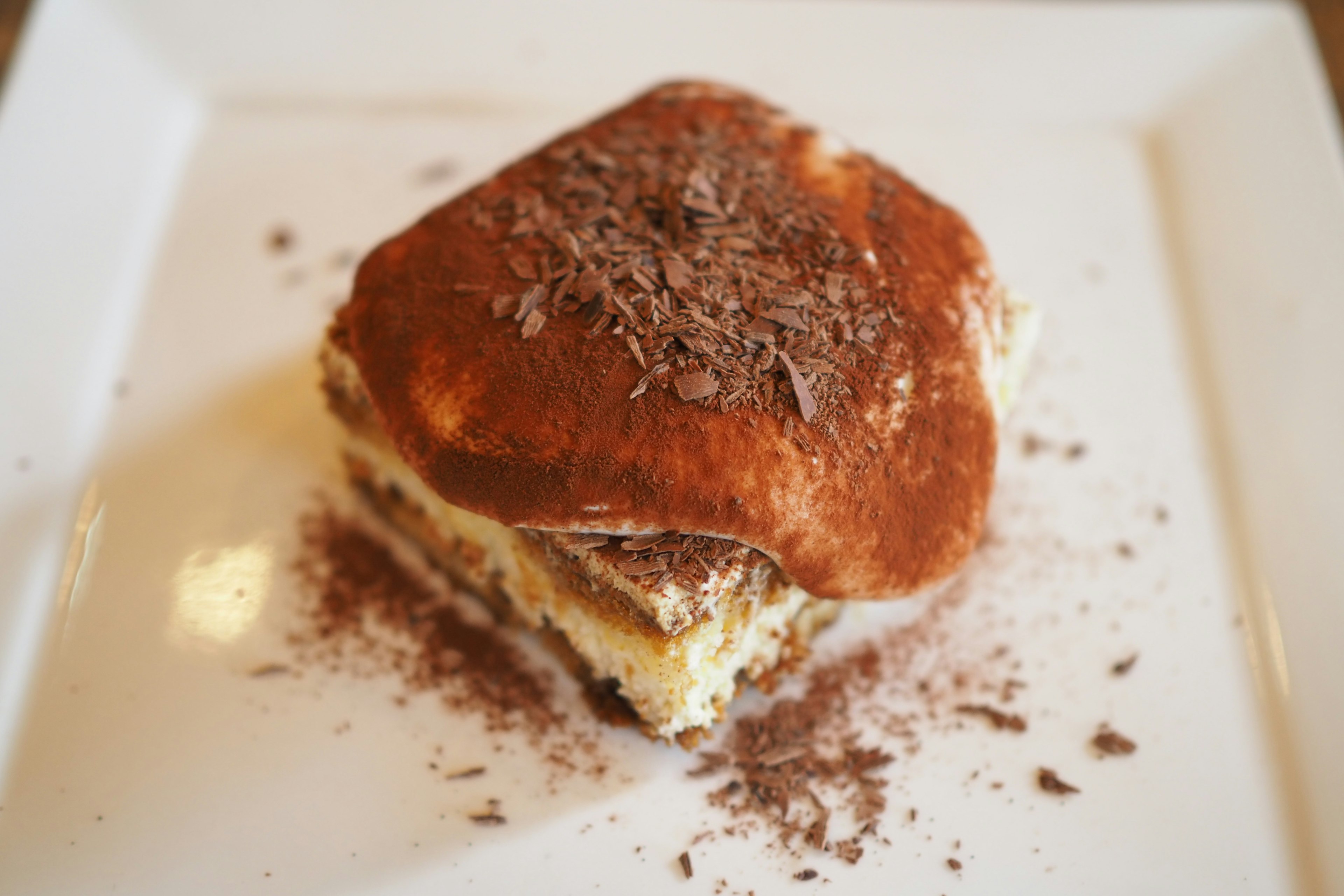 Delicioso postre tiramisú cubierto con cacao en polvo y virutas de chocolate