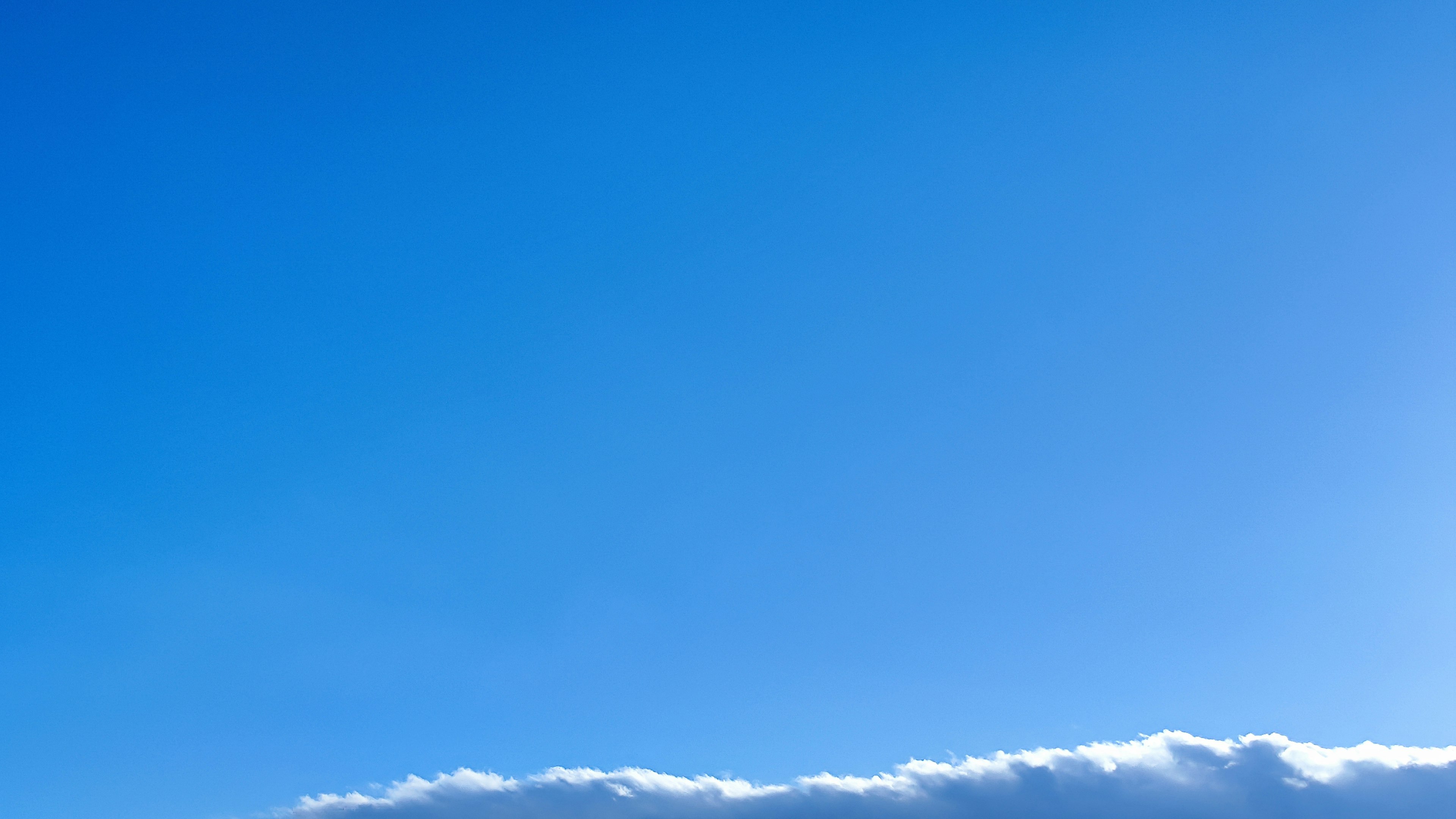 Weitläufiger blauer Himmel mit flauschigen weißen Wolken