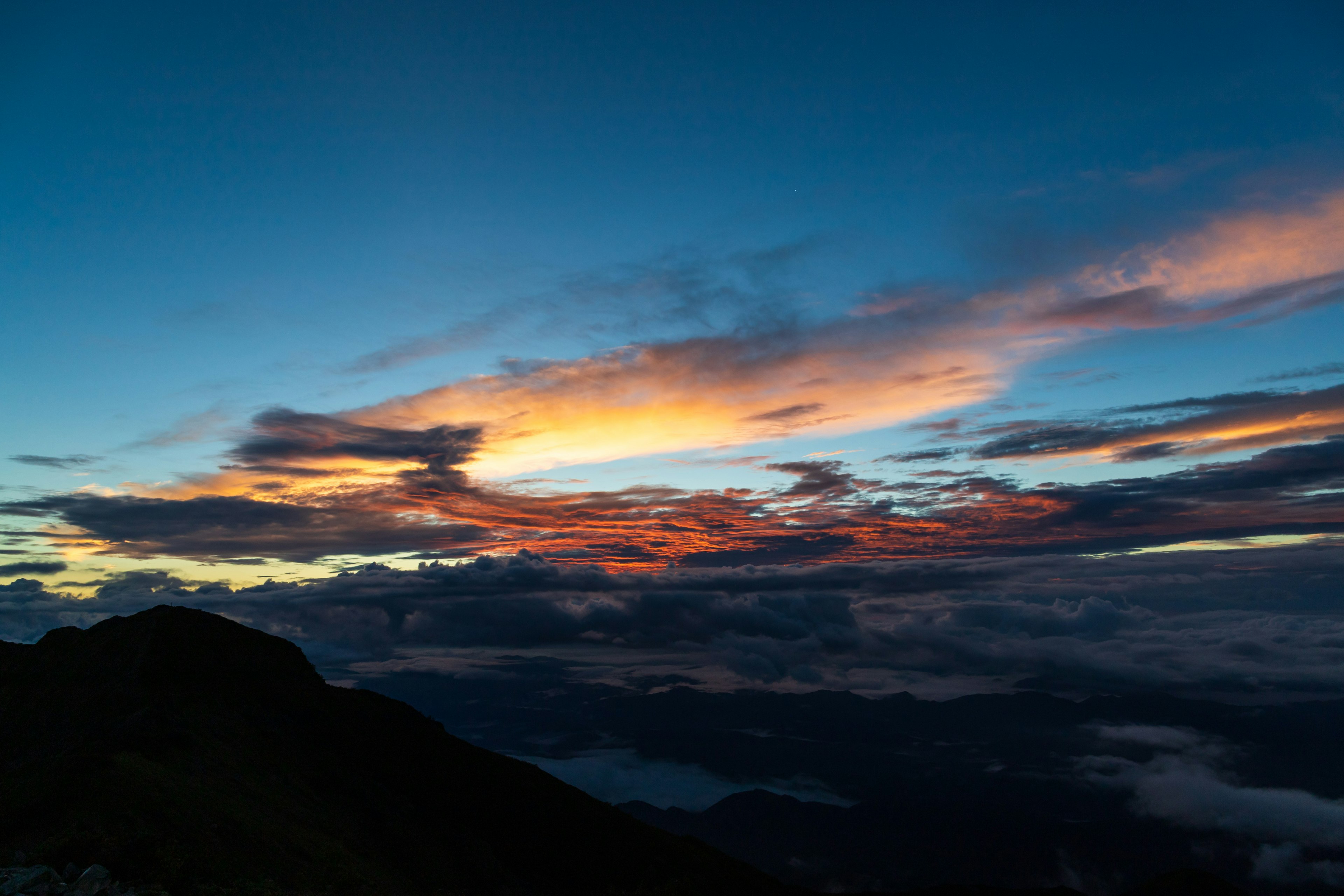 夕焼けの空と山のシルエットが映える美しい風景