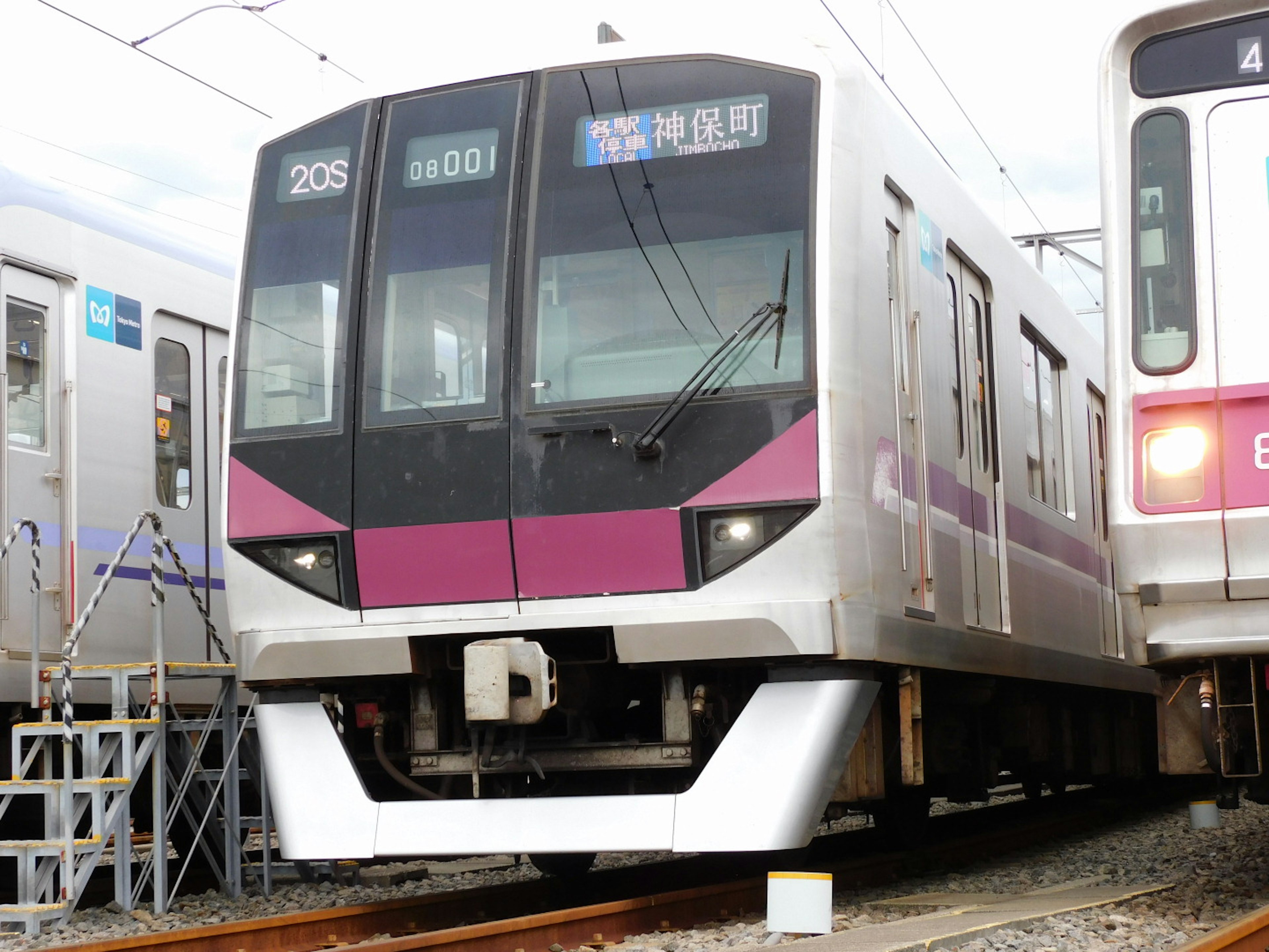 Japanese train with a purple design stopped at the station