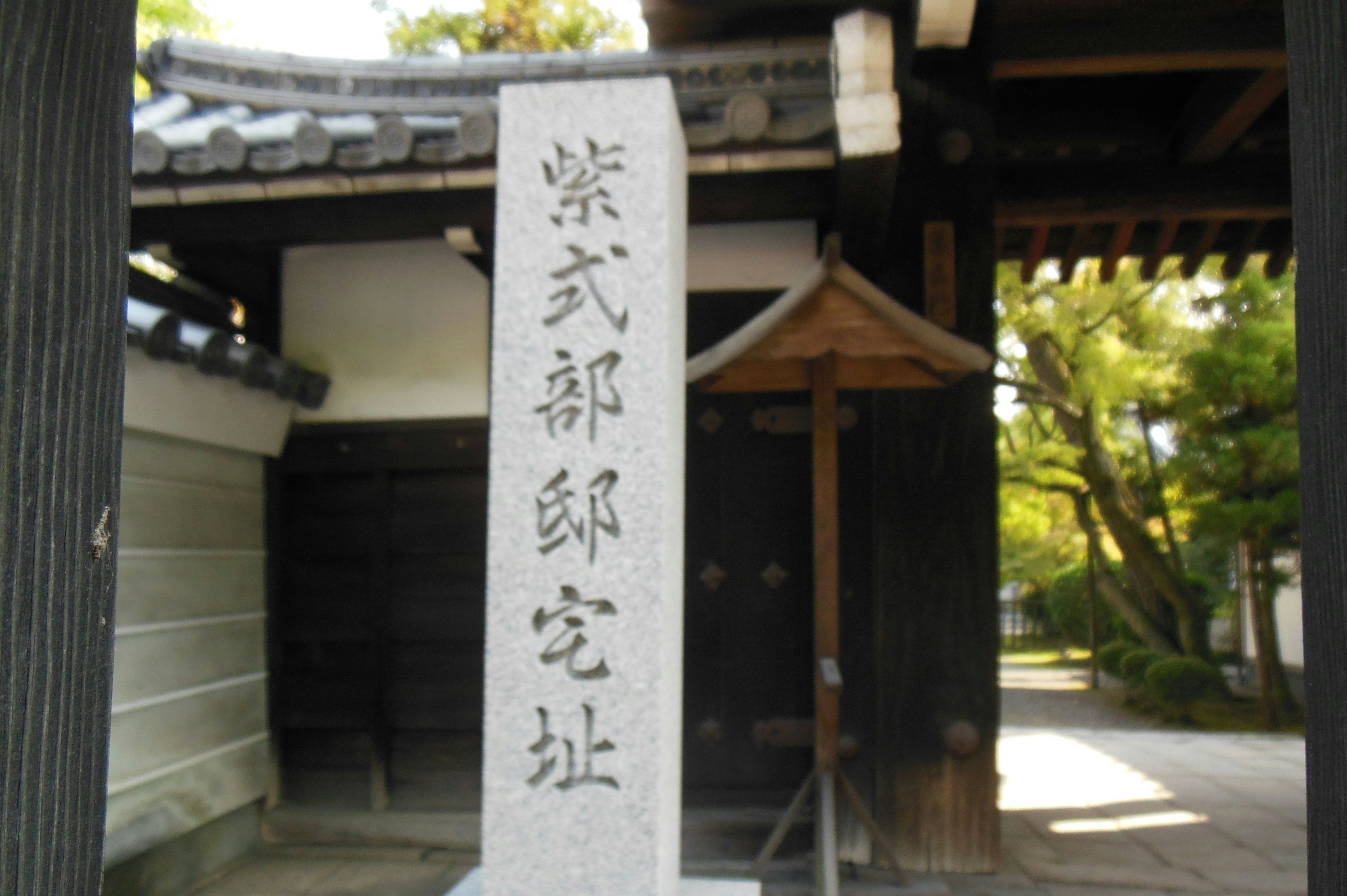 Historic stone marker at a traditional Japanese gate