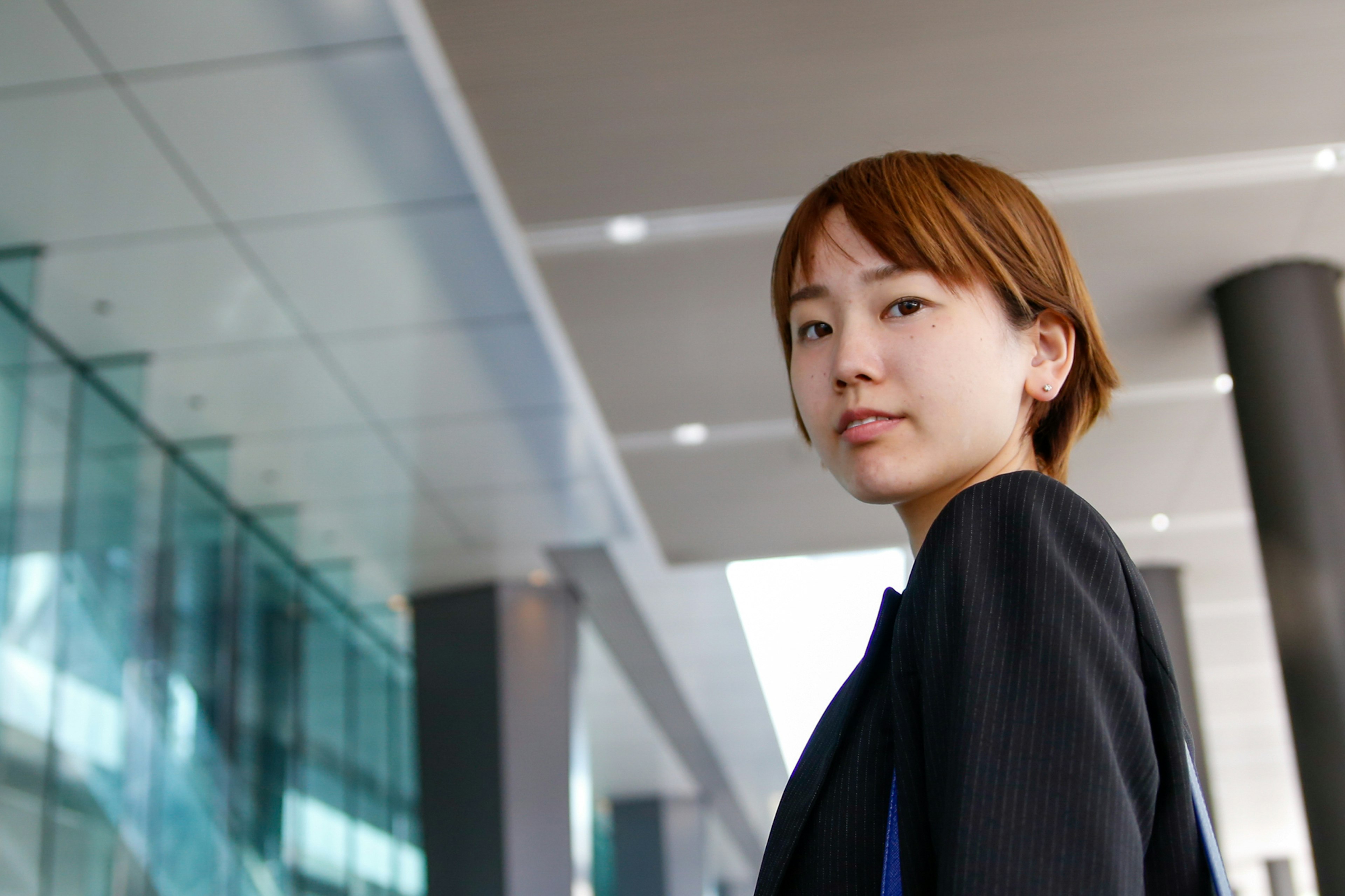 A confident woman wearing a business suit standing outdoors