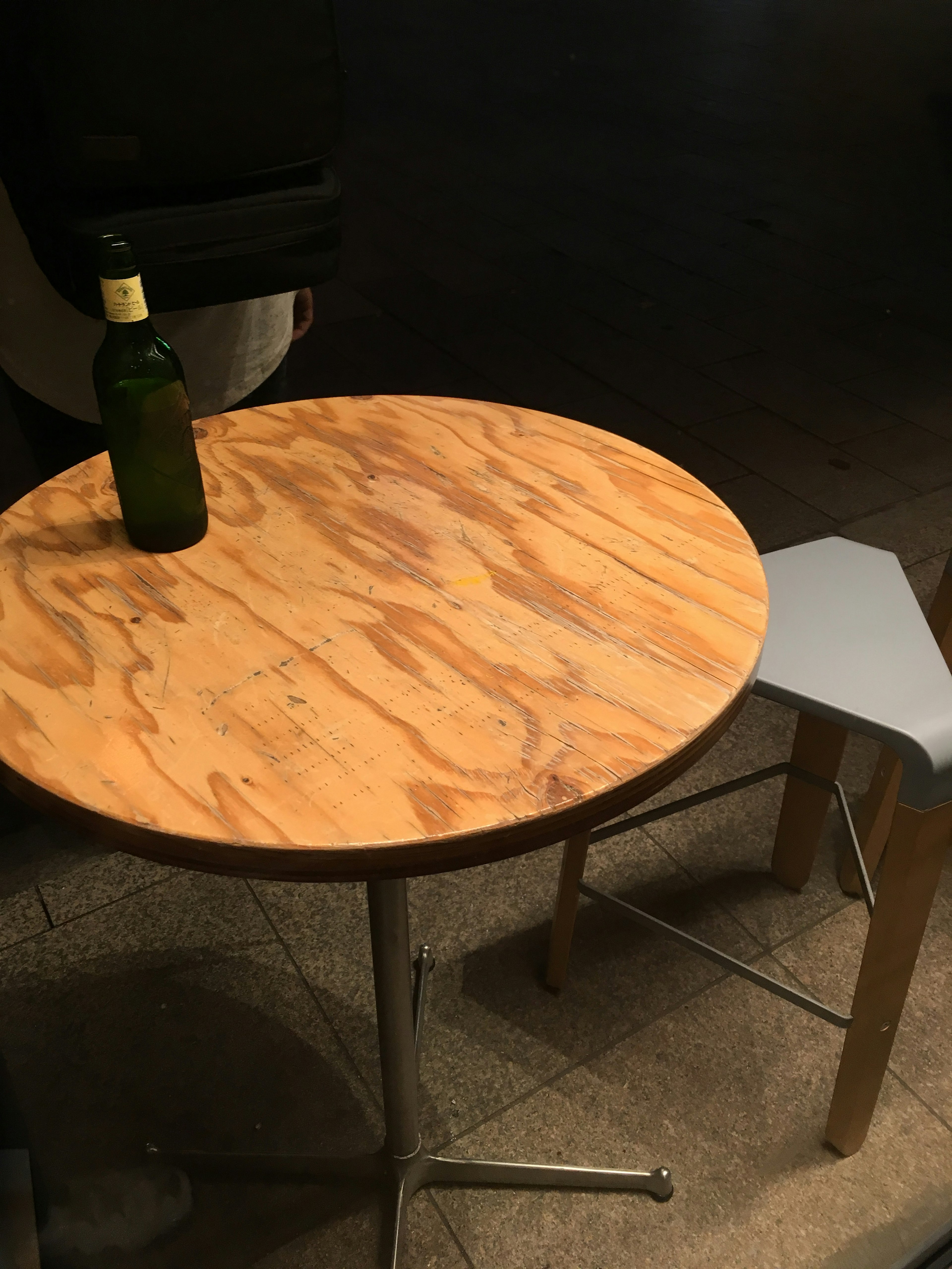 A simple interior featuring a round wooden table and a gray chair