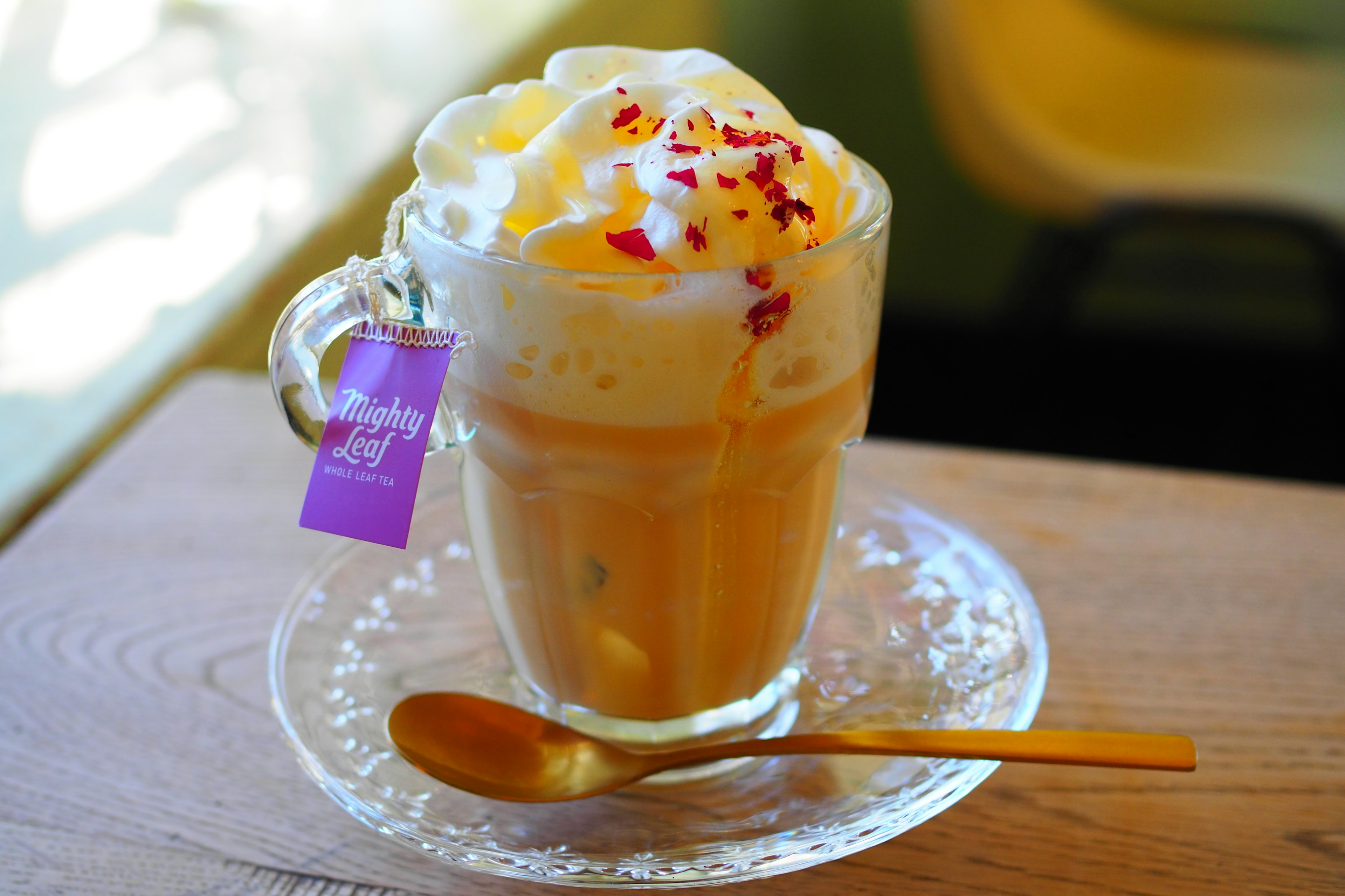 Une boisson dans une tasse garnie de crème et de pétales de fleurs