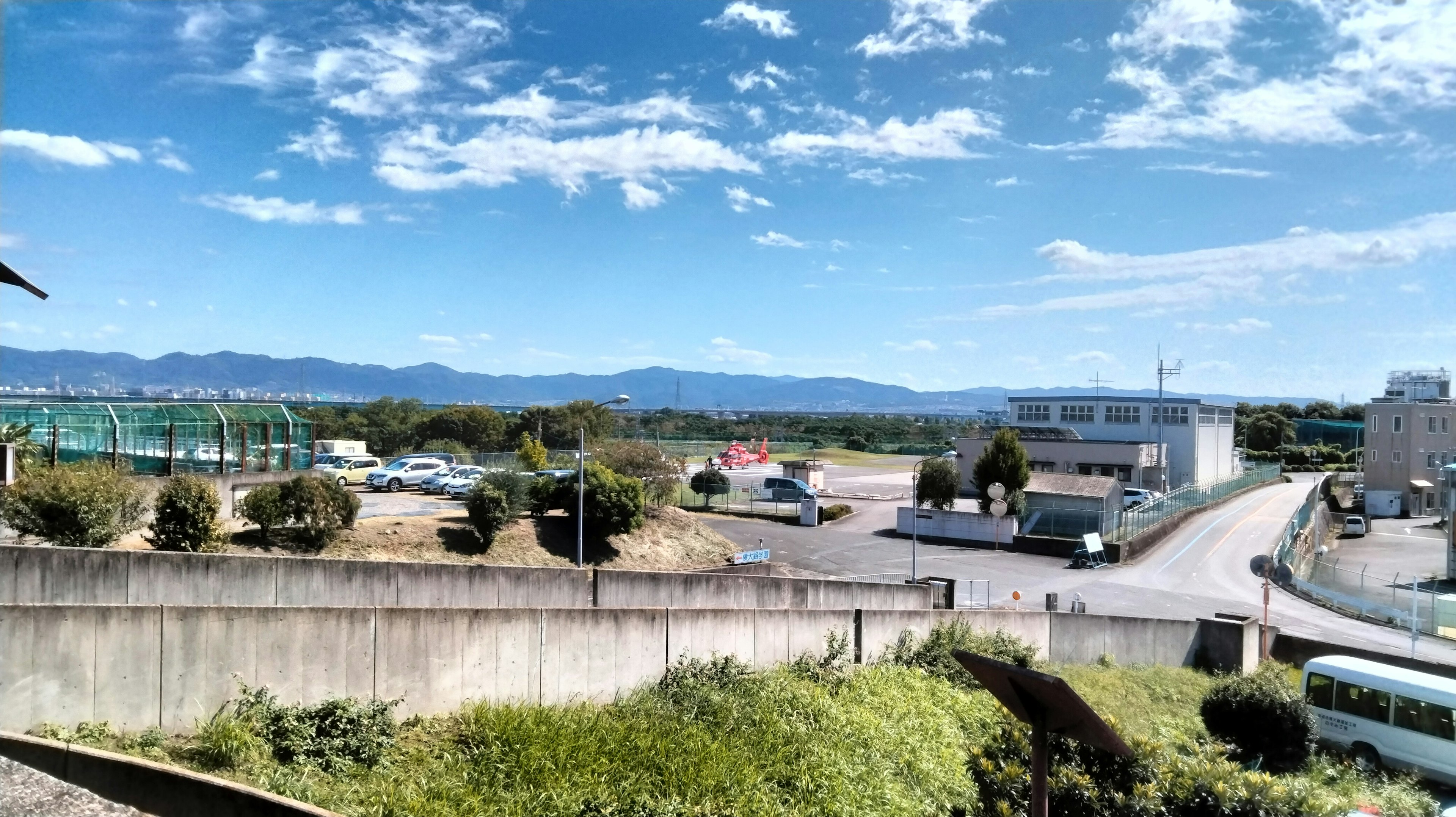 Vista panorámica con cielo azul y nubes que muestra colinas y edificios