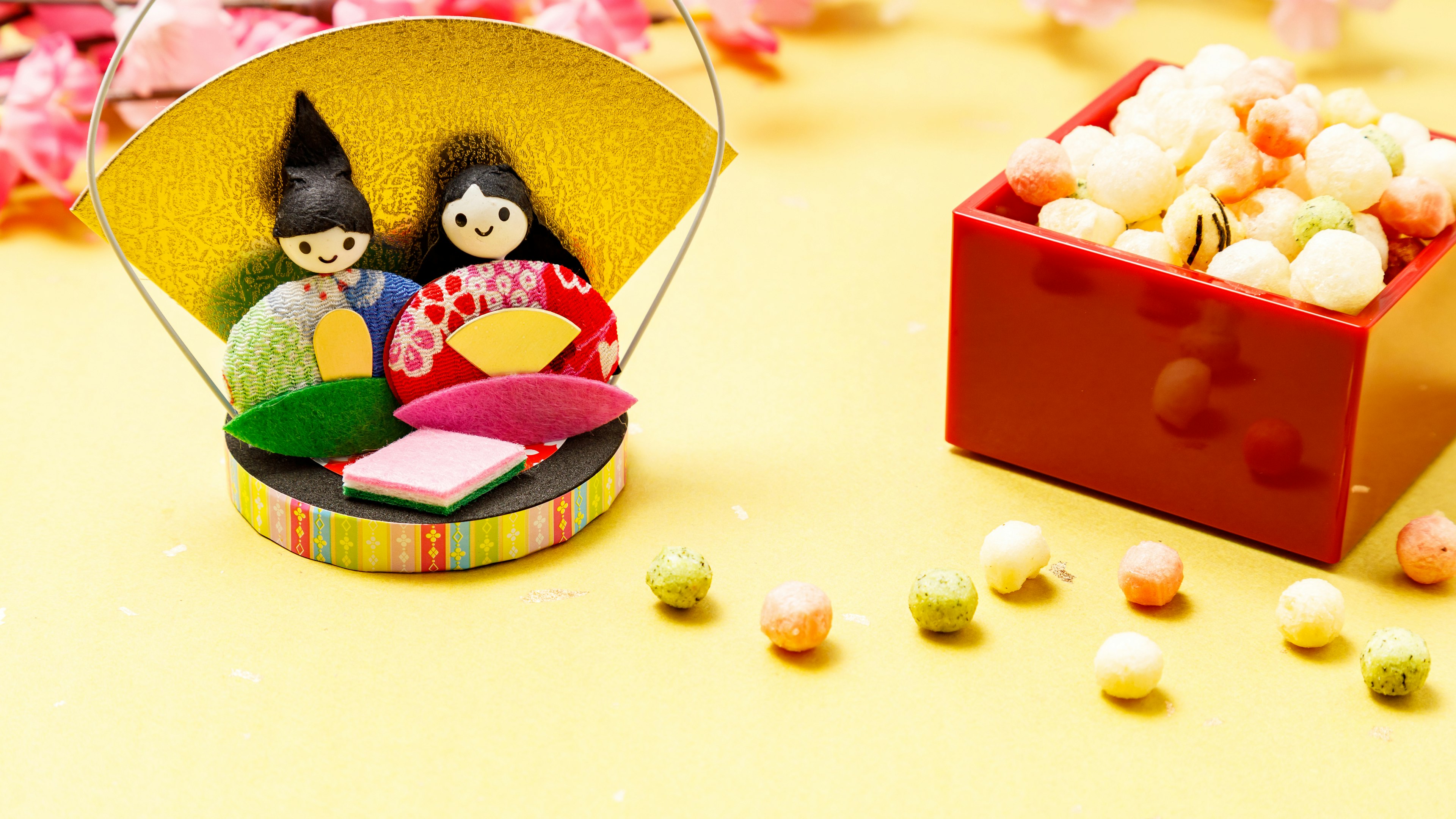 Muñecas tradicionales relacionadas con Hinamatsuri con una disposición de dulces coloridos