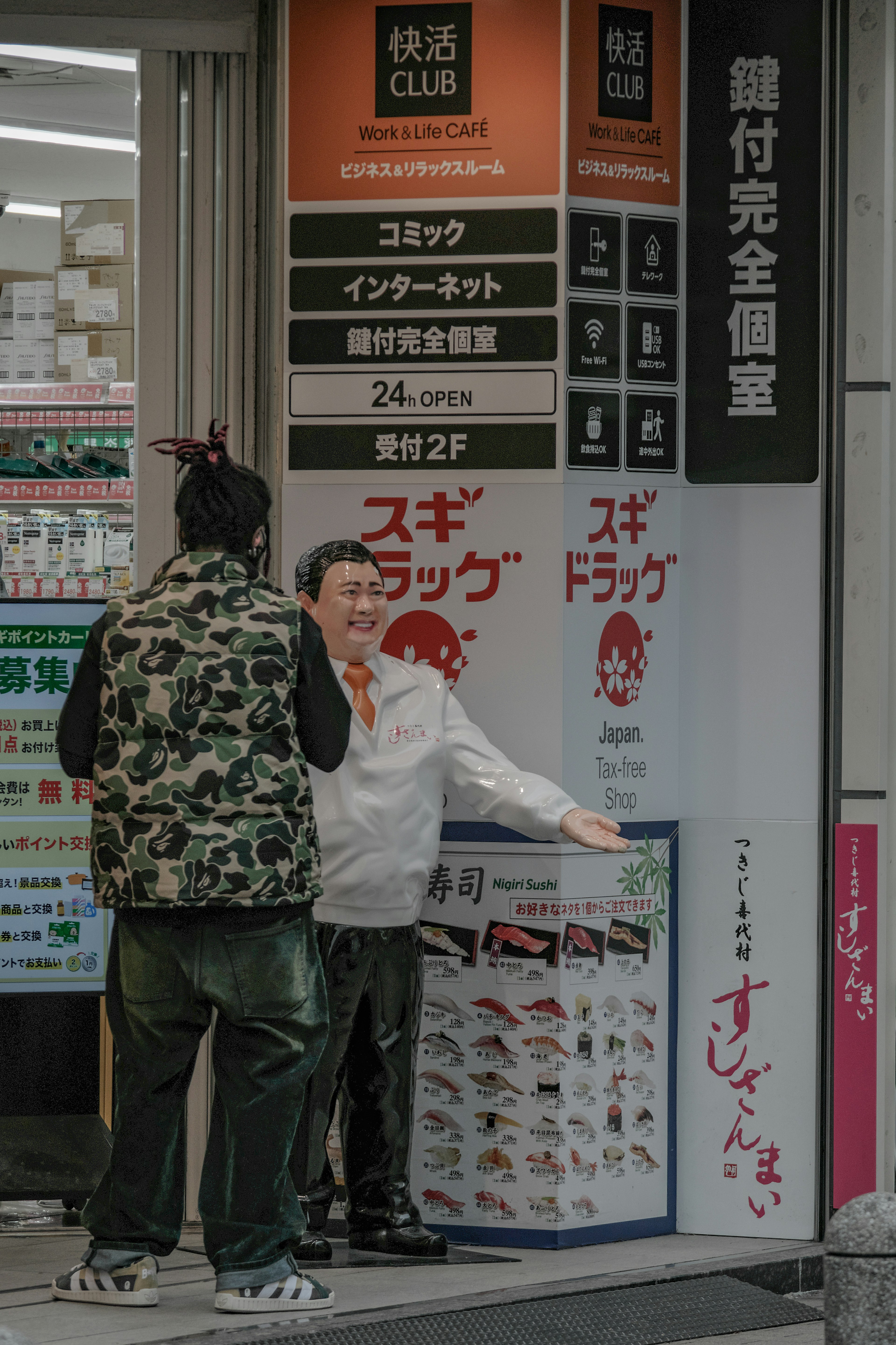 Two men talking in front of a store with signage