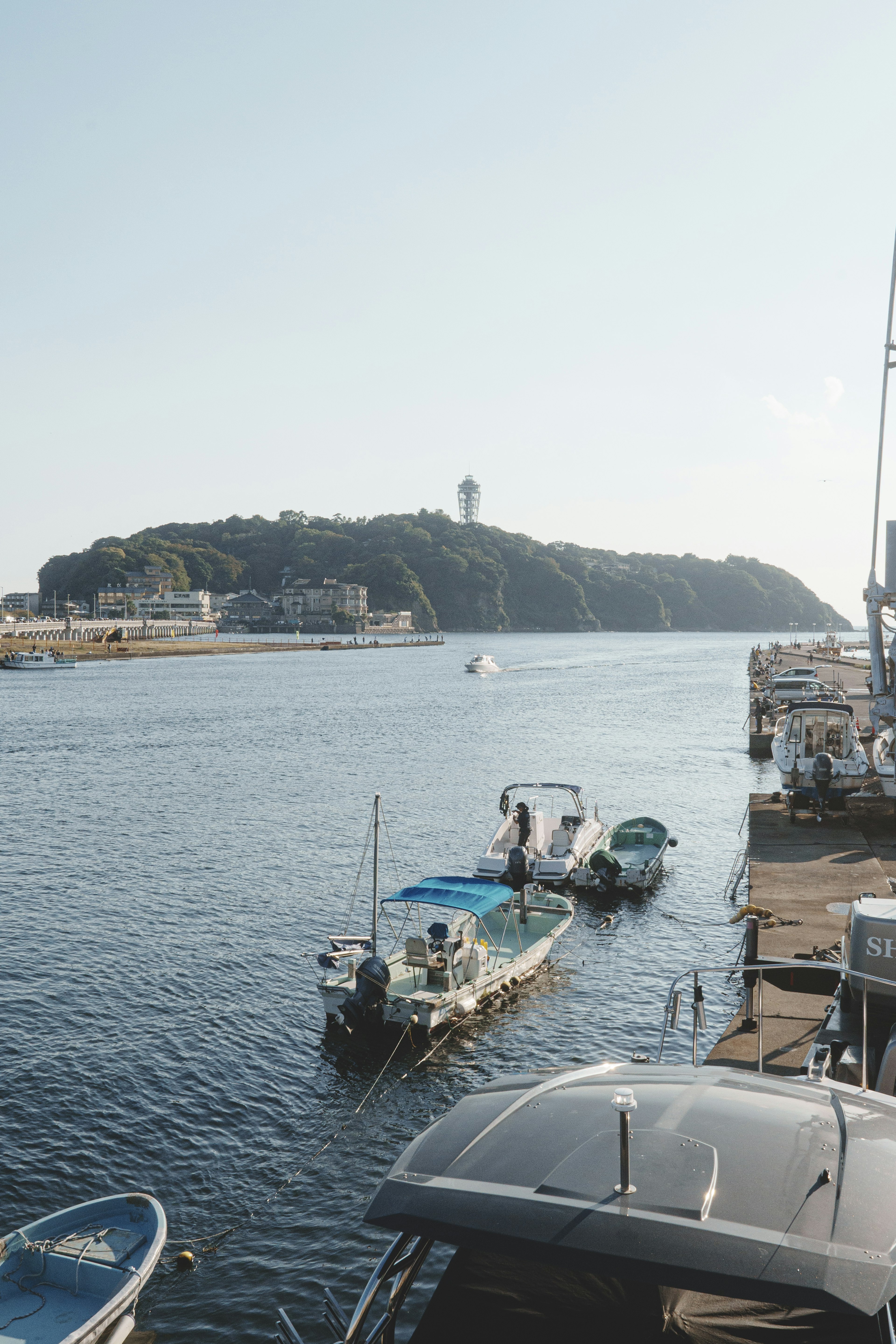 Malersicher Blick auf kleine Boote auf ruhigem Wasser mit einer Insel im Hintergrund