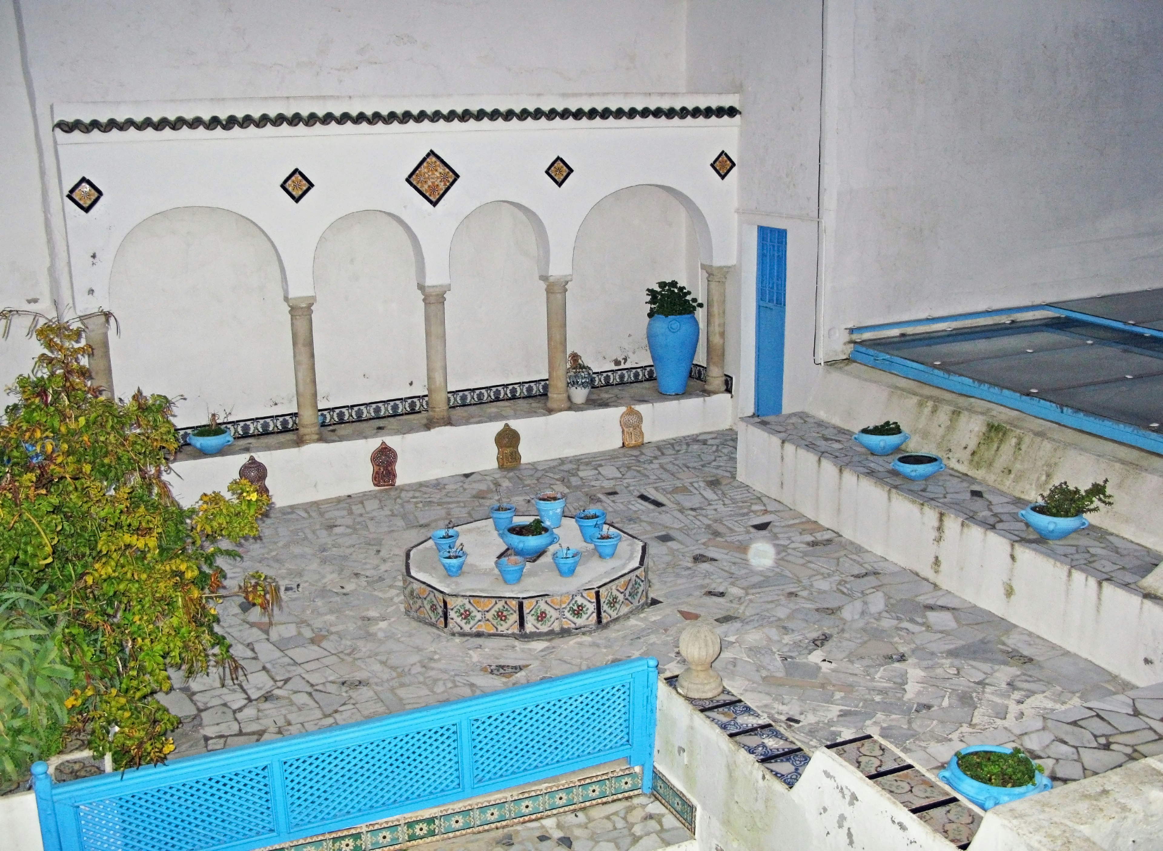 Vue de cour avec des pots bleus et une terrasse en pierre