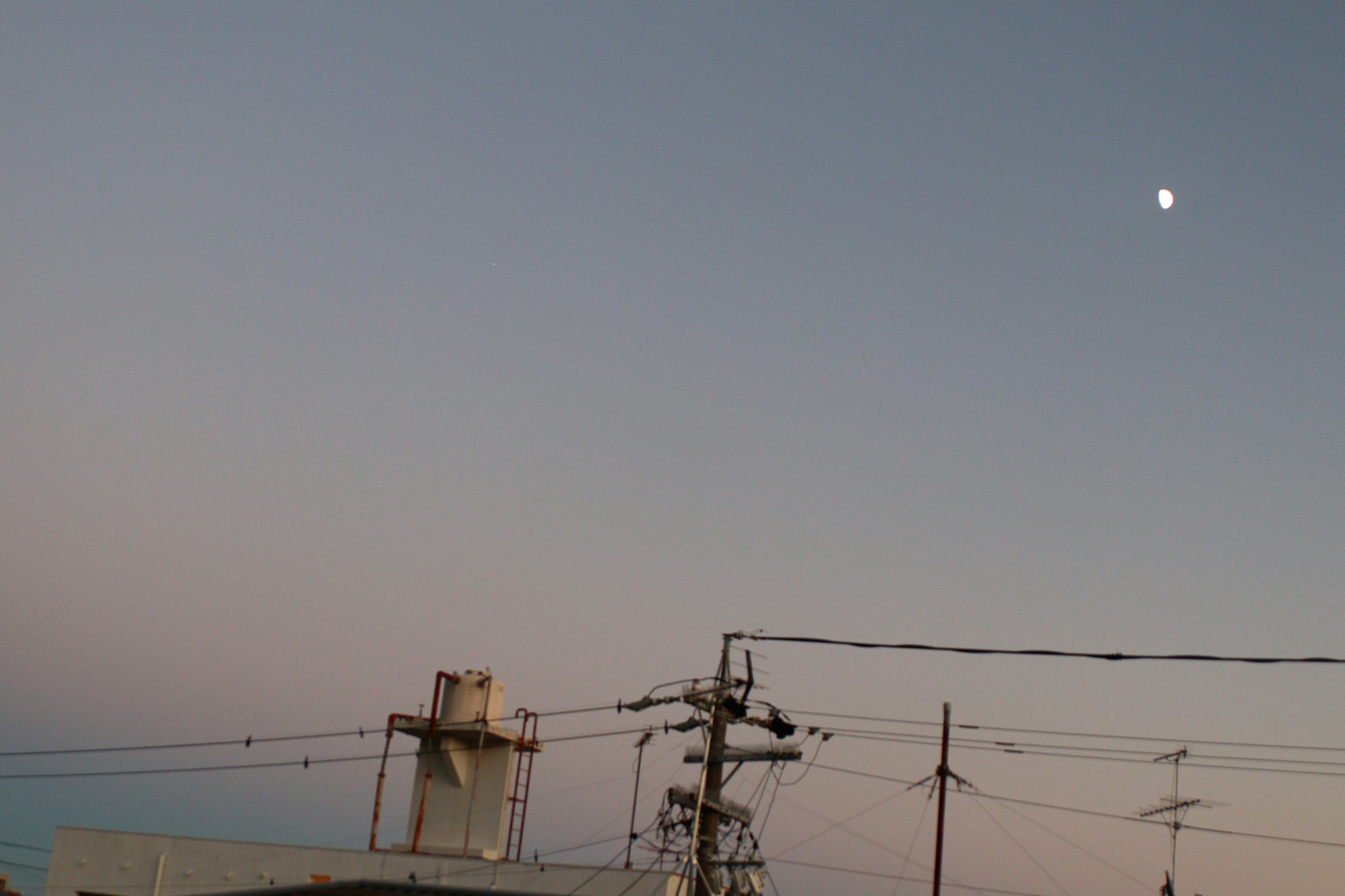 Moon in a twilight sky with power lines