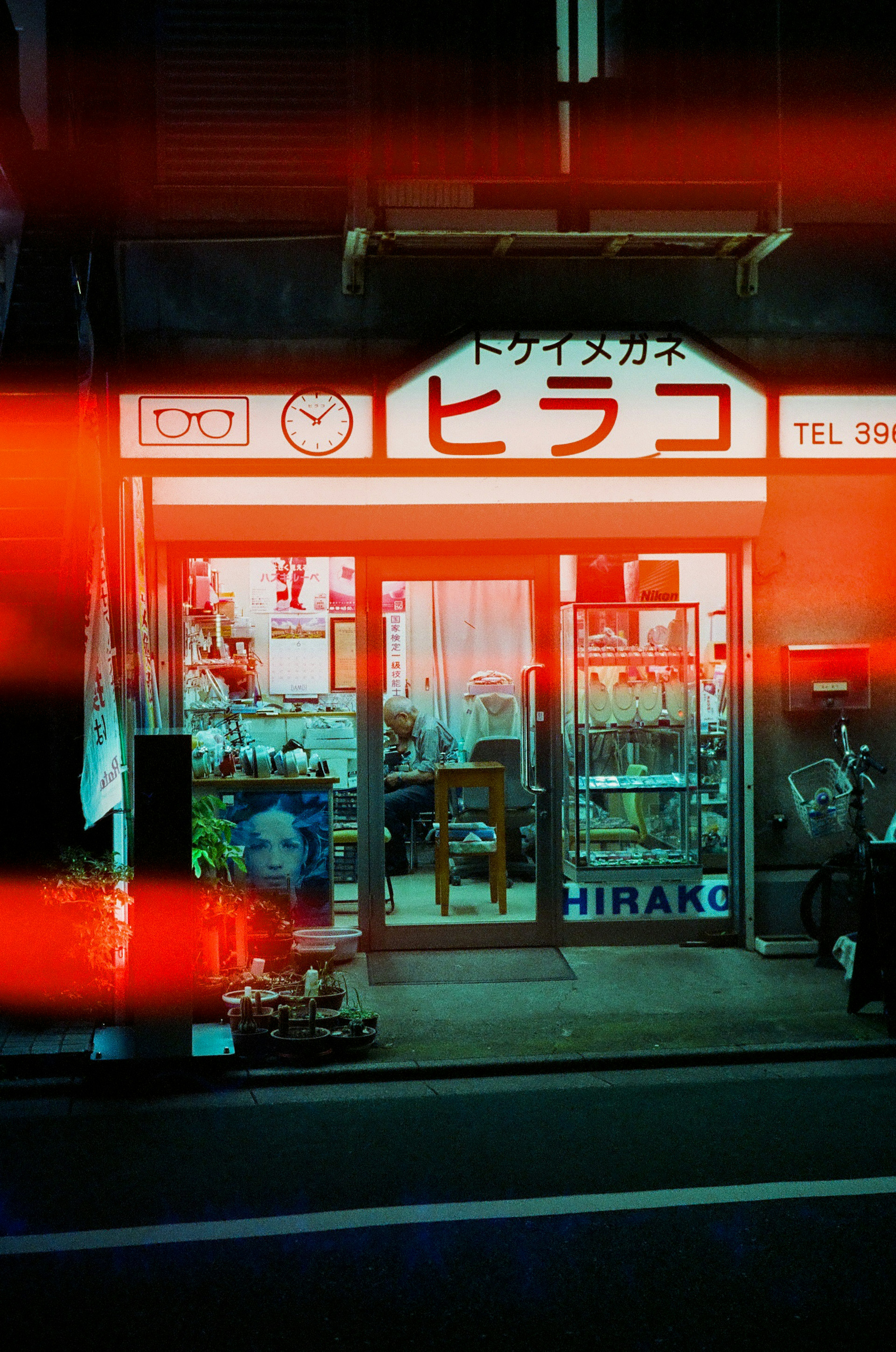 Storefront with prominent red neon sign featuring the name Hirako showcasing various items inside