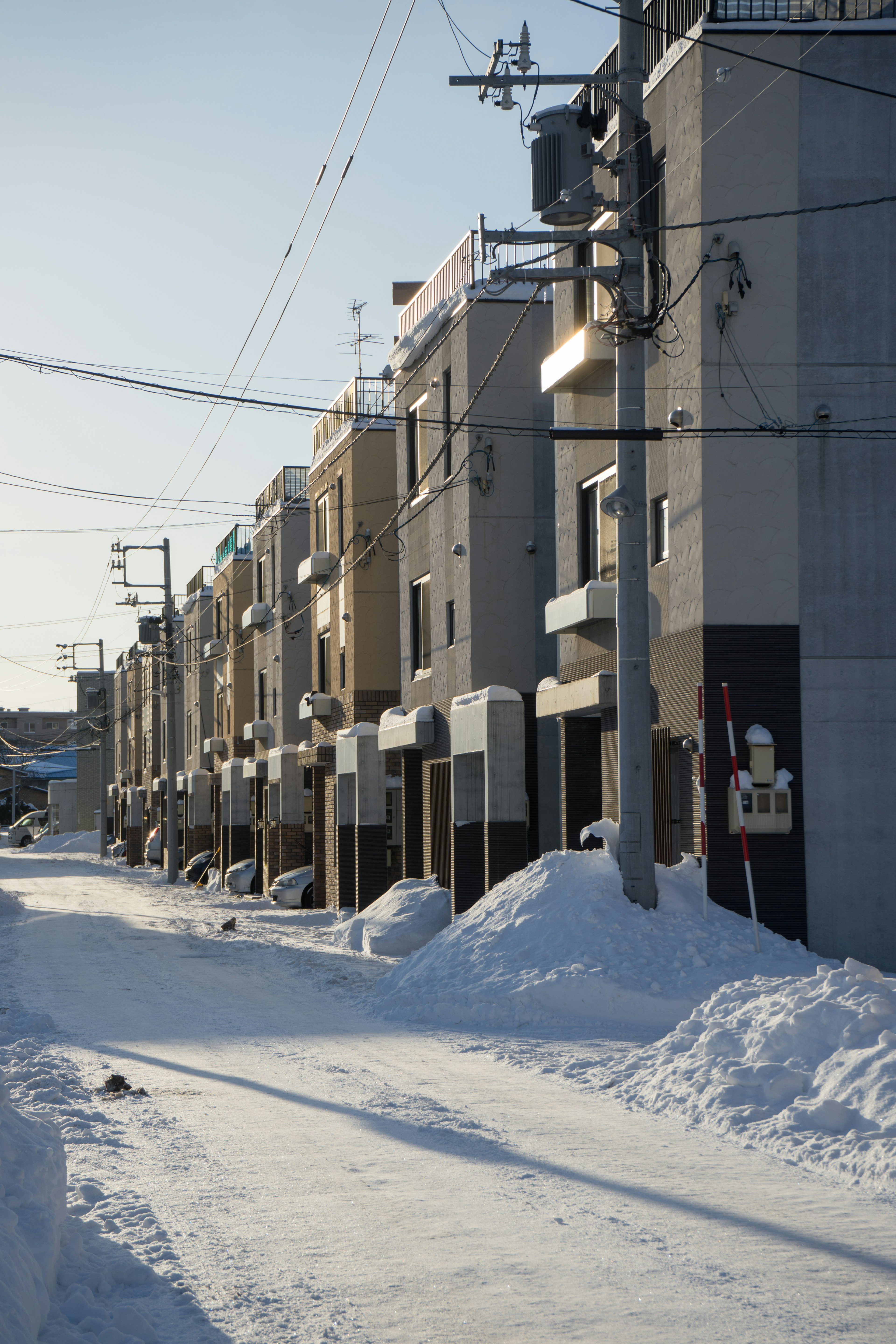 Snow-covered street lined with residential buildings