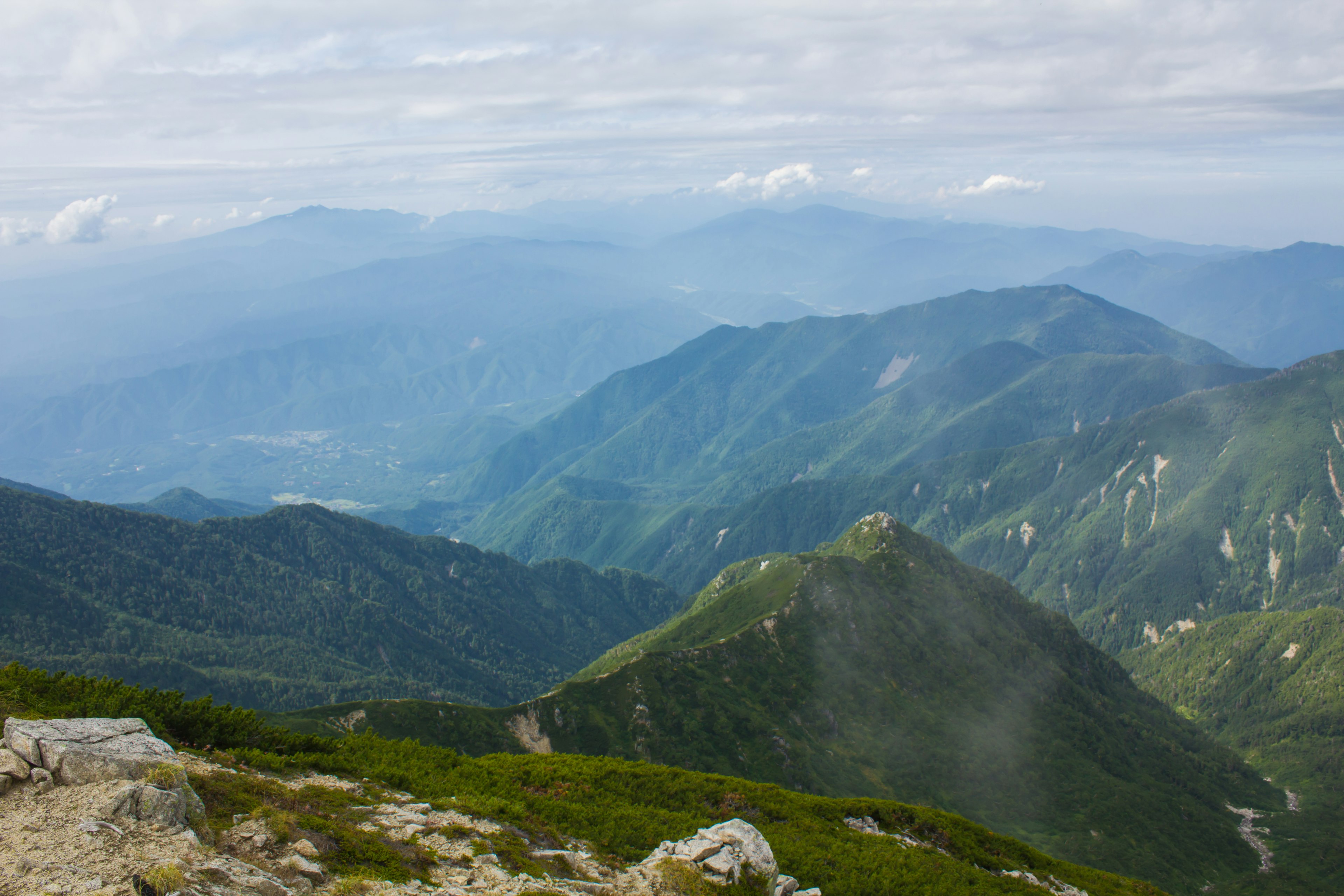 Vista panoramica di montagne verdi sotto un cielo nuvoloso