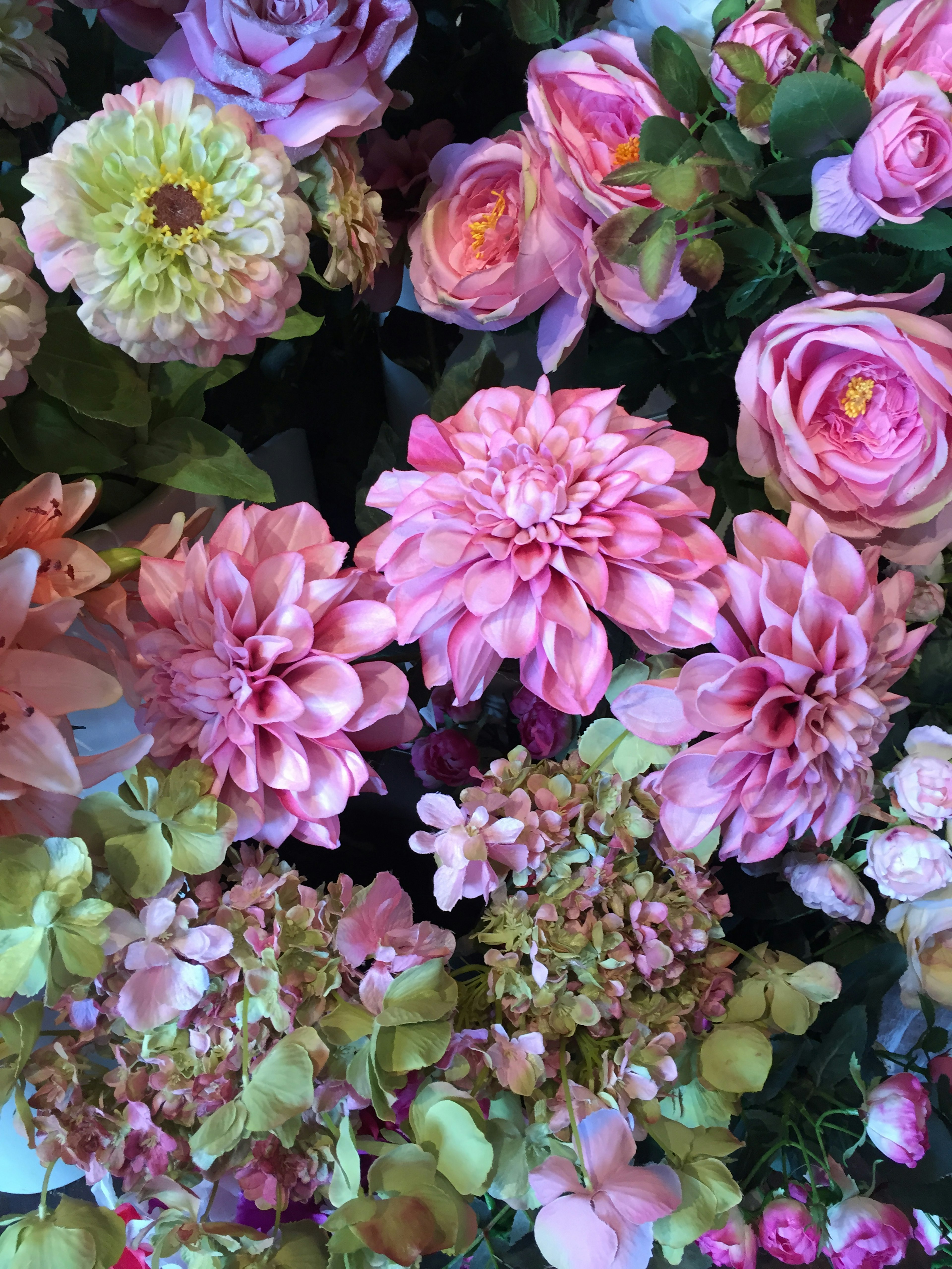 A beautiful arrangement of colorful flowers including pink roses and dahlias