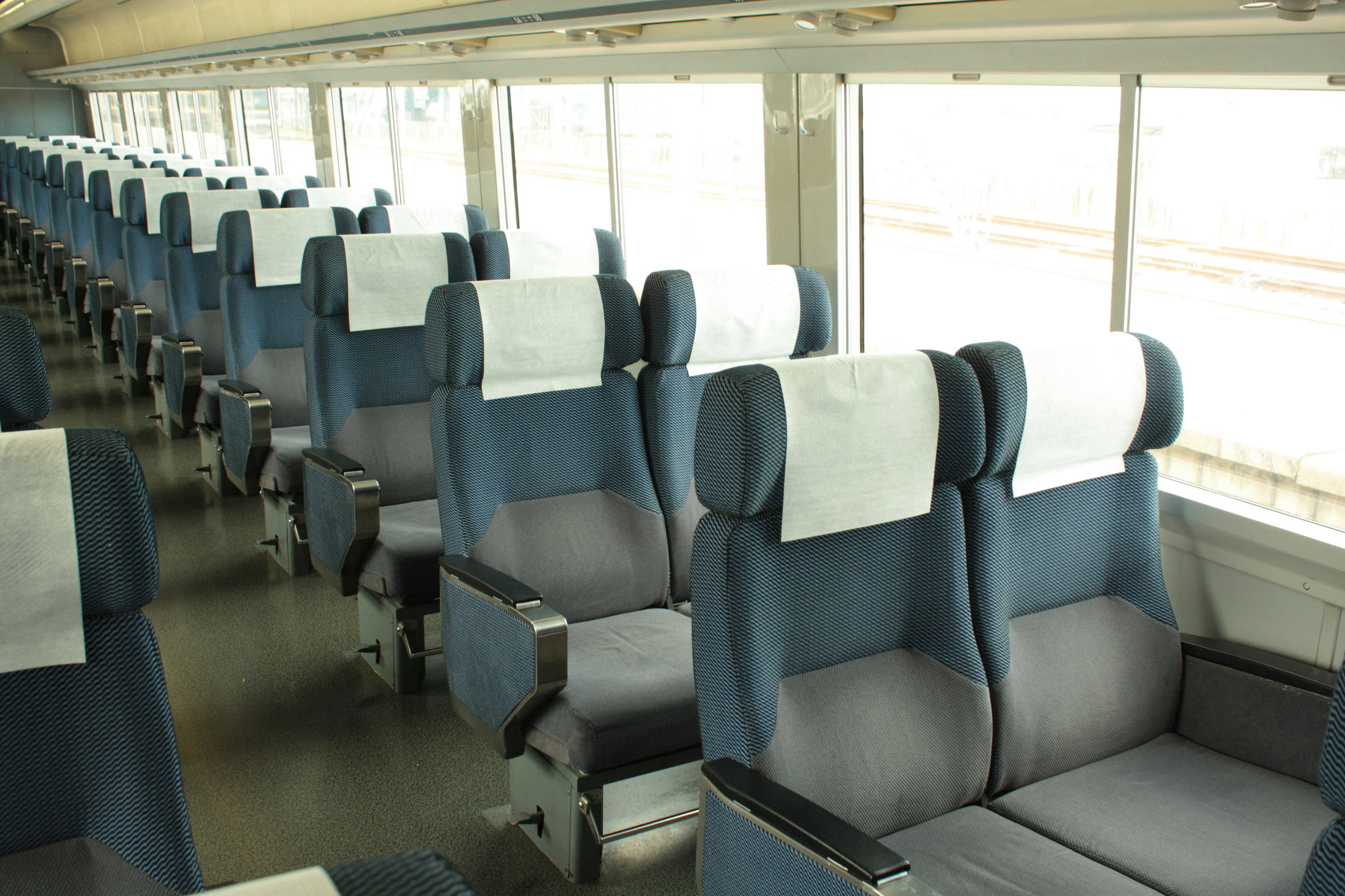 Interior of a train carriage with empty seats arranged in rows