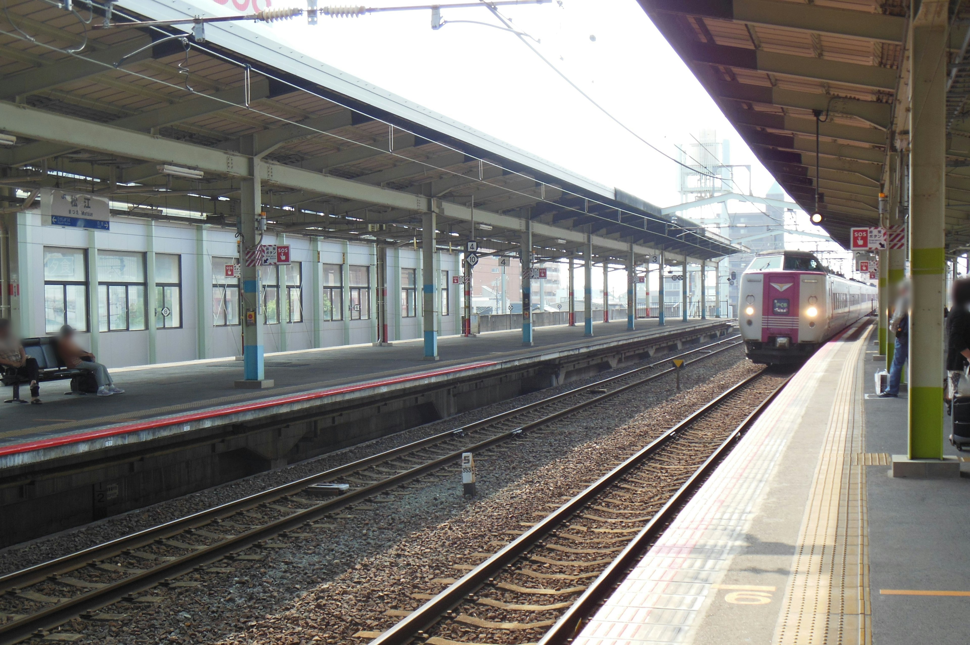 Train at a platform with surrounding buildings