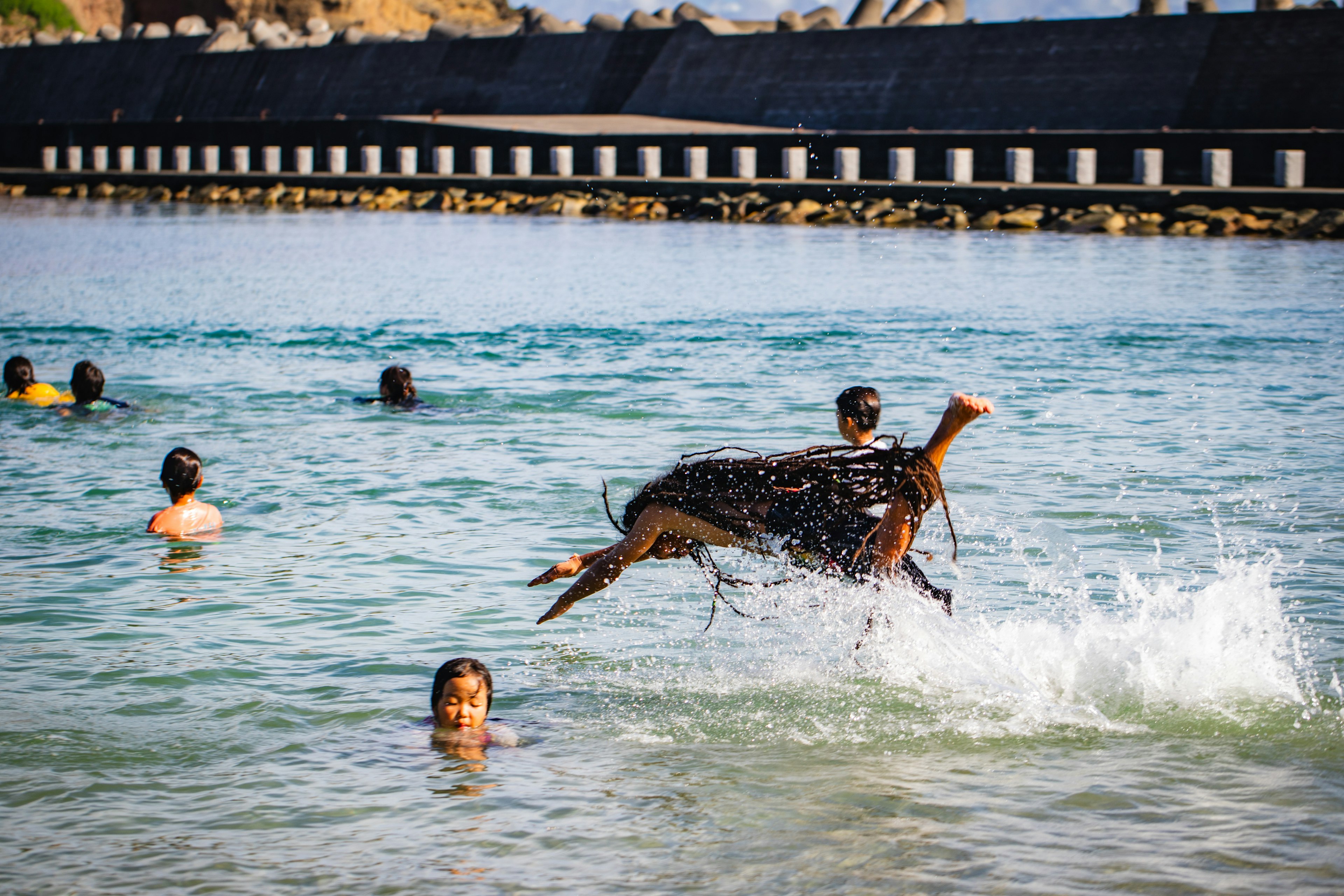 Bild von Menschen, die im Wasser spielen, mit einem springenden Hund