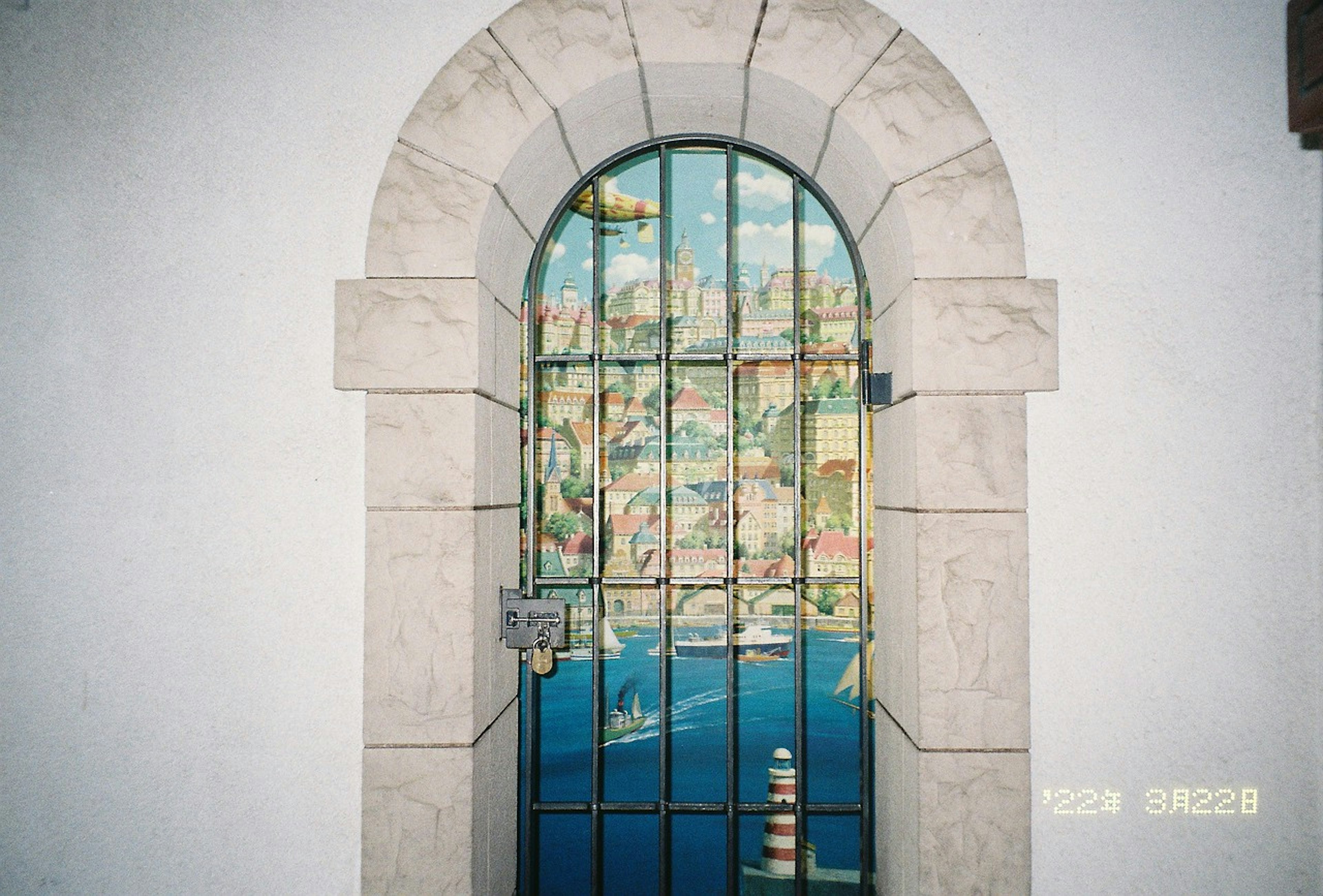 Artistic window featuring a coastal town and blue sea