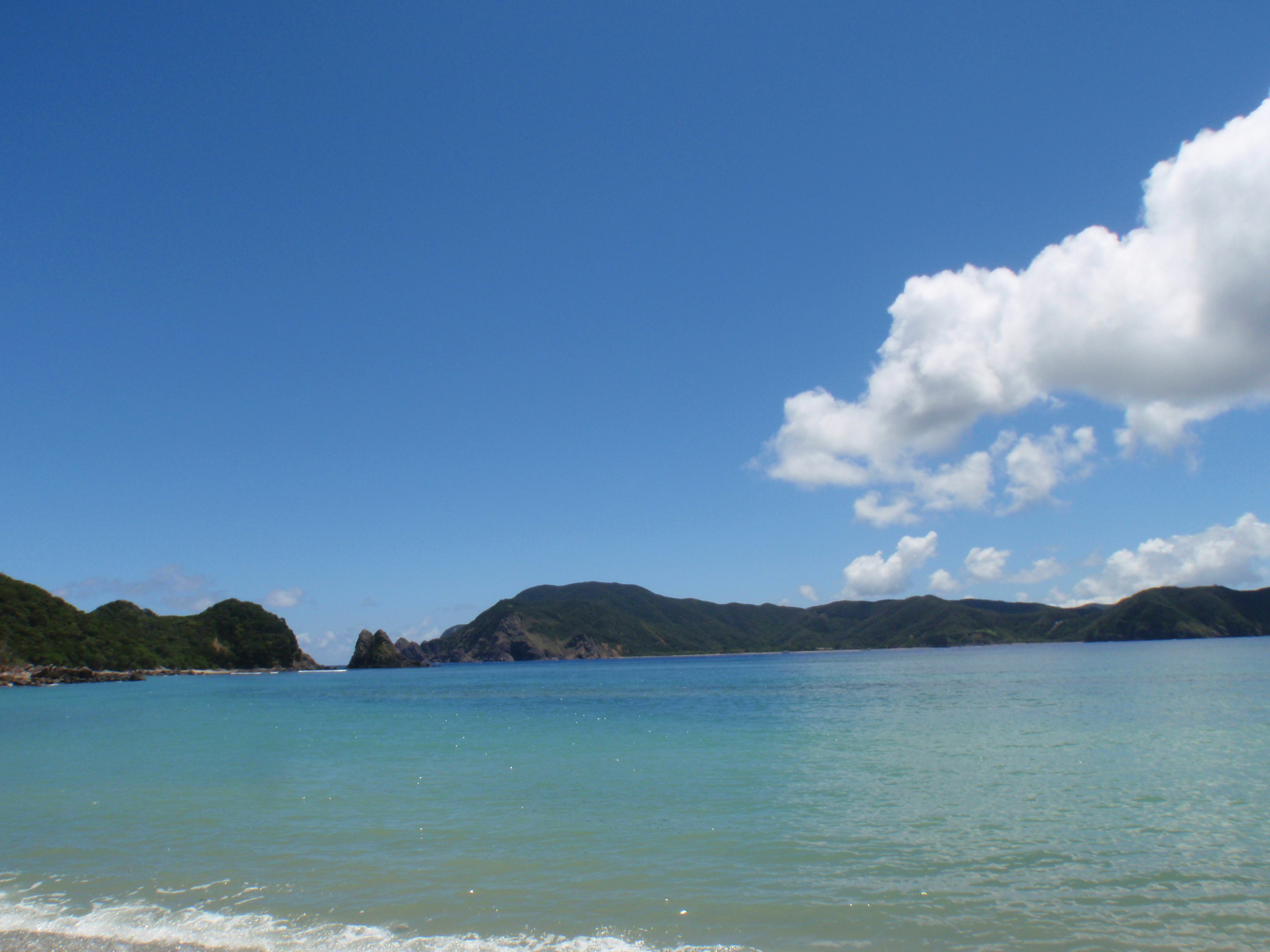 Scenic beach view with blue ocean and white clouds