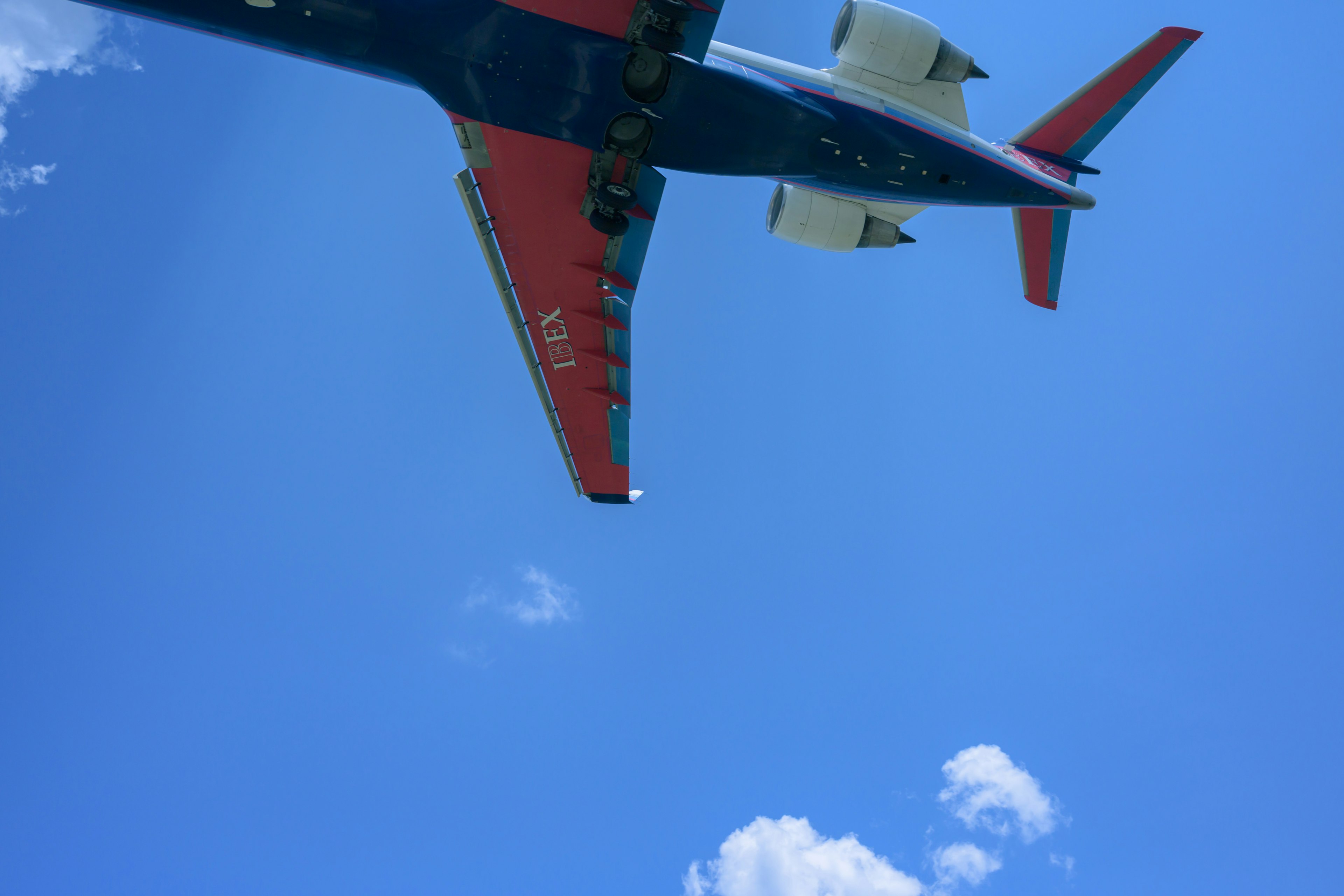 Un aereo che vola contro un cielo blu chiaro