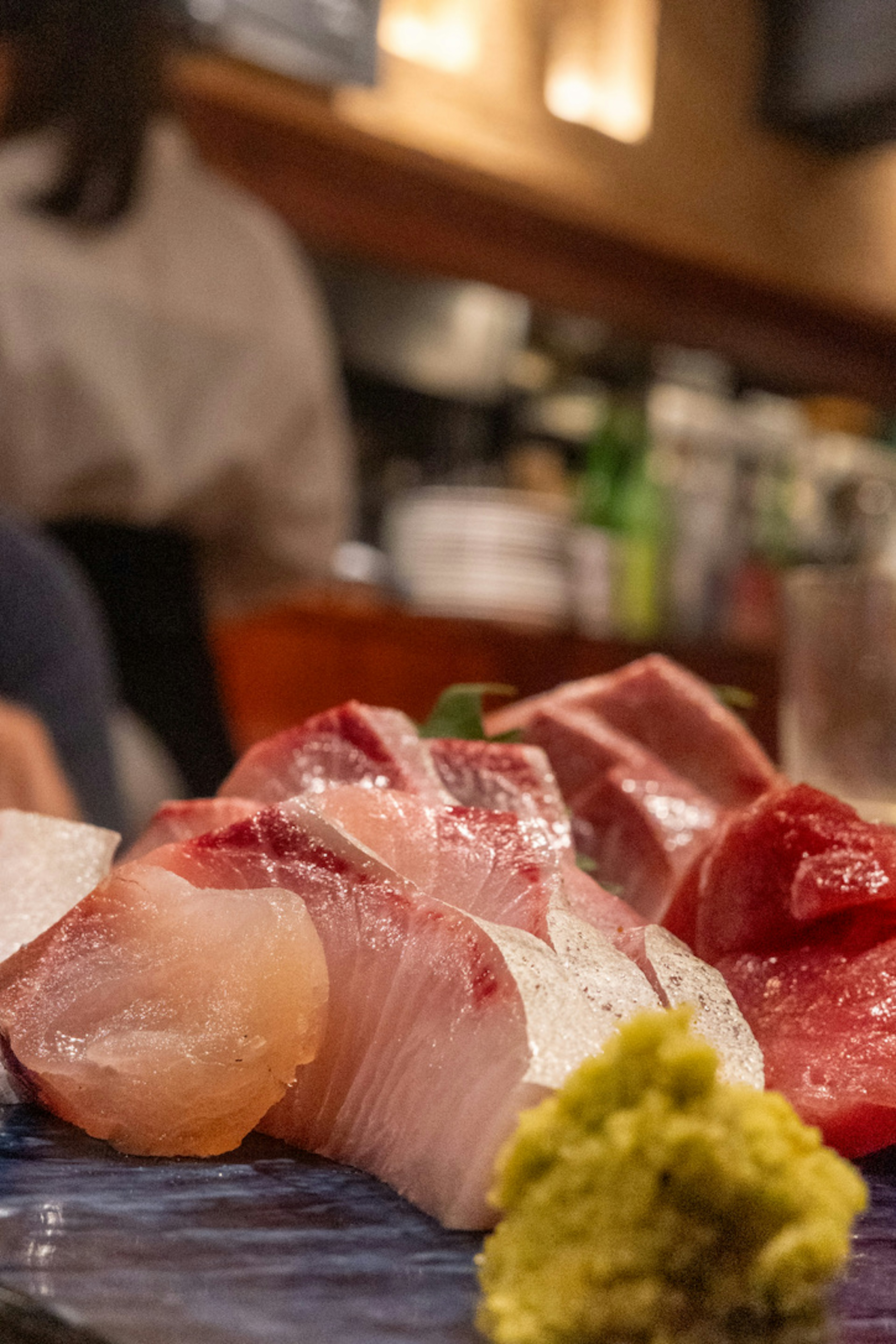 Frisches Sashimi-Arrangement mit Wasabi auf einem blauen Teller