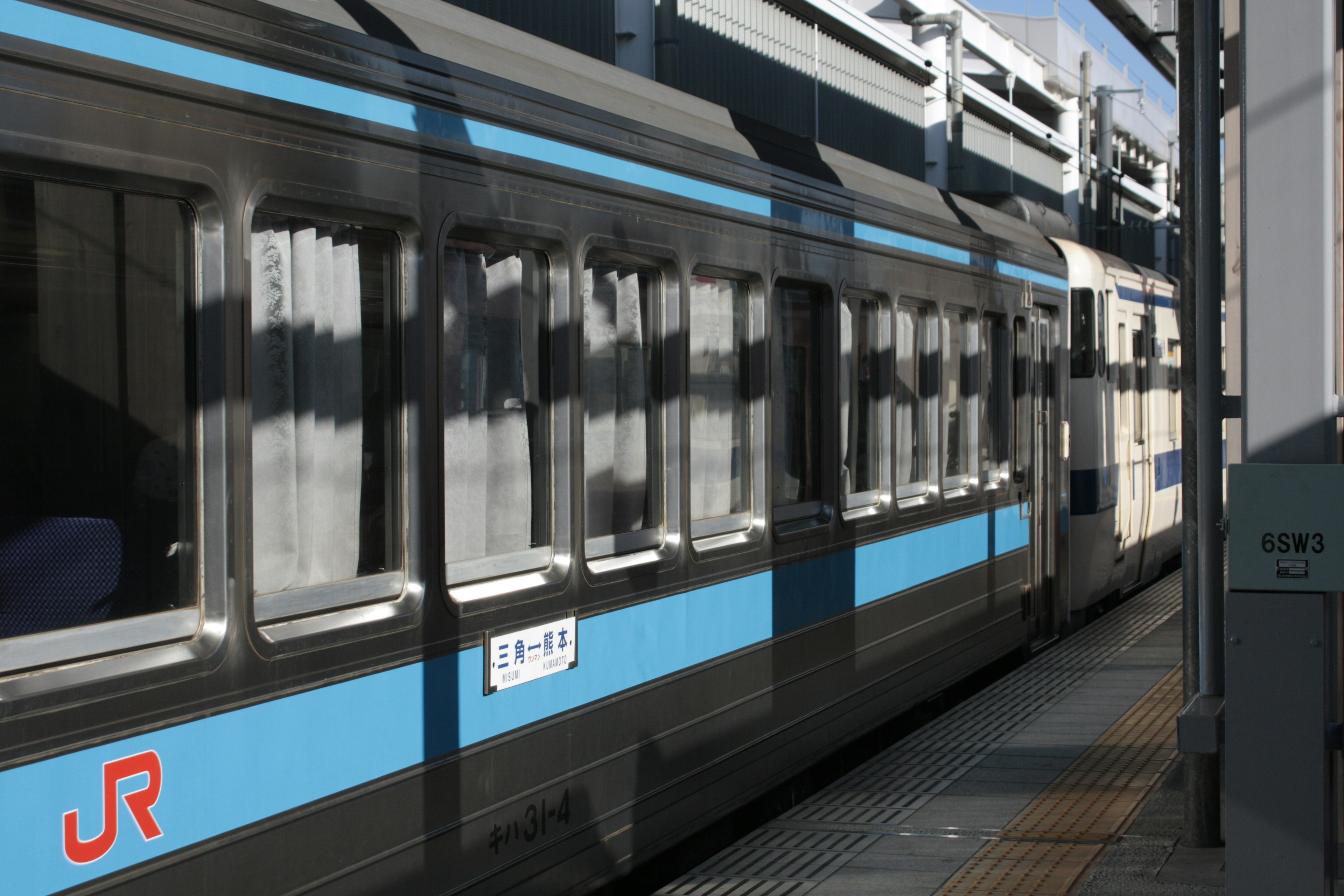 青いラインのある列車が駅に停車している