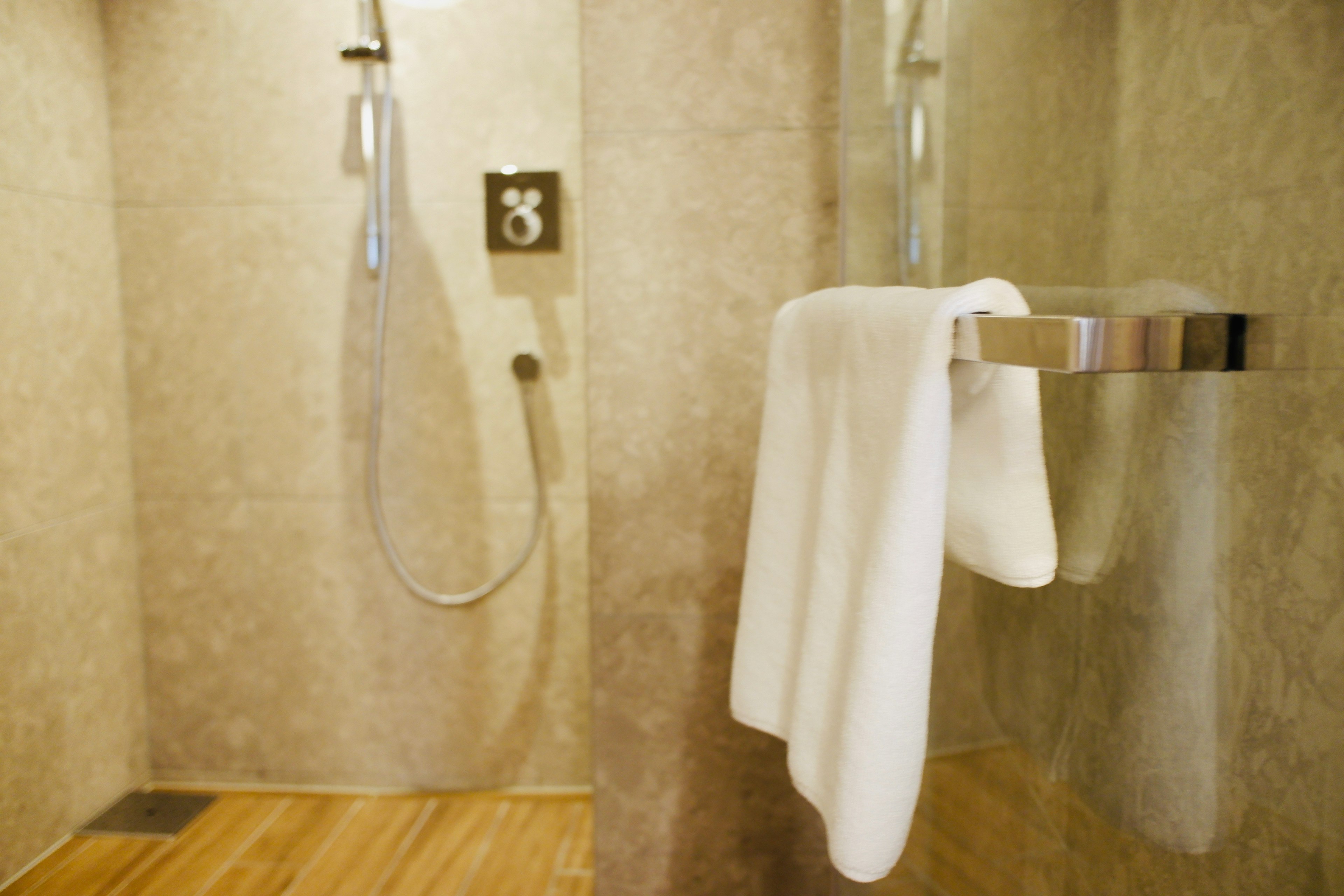 Shower area with a hanging white towel and modern fixtures