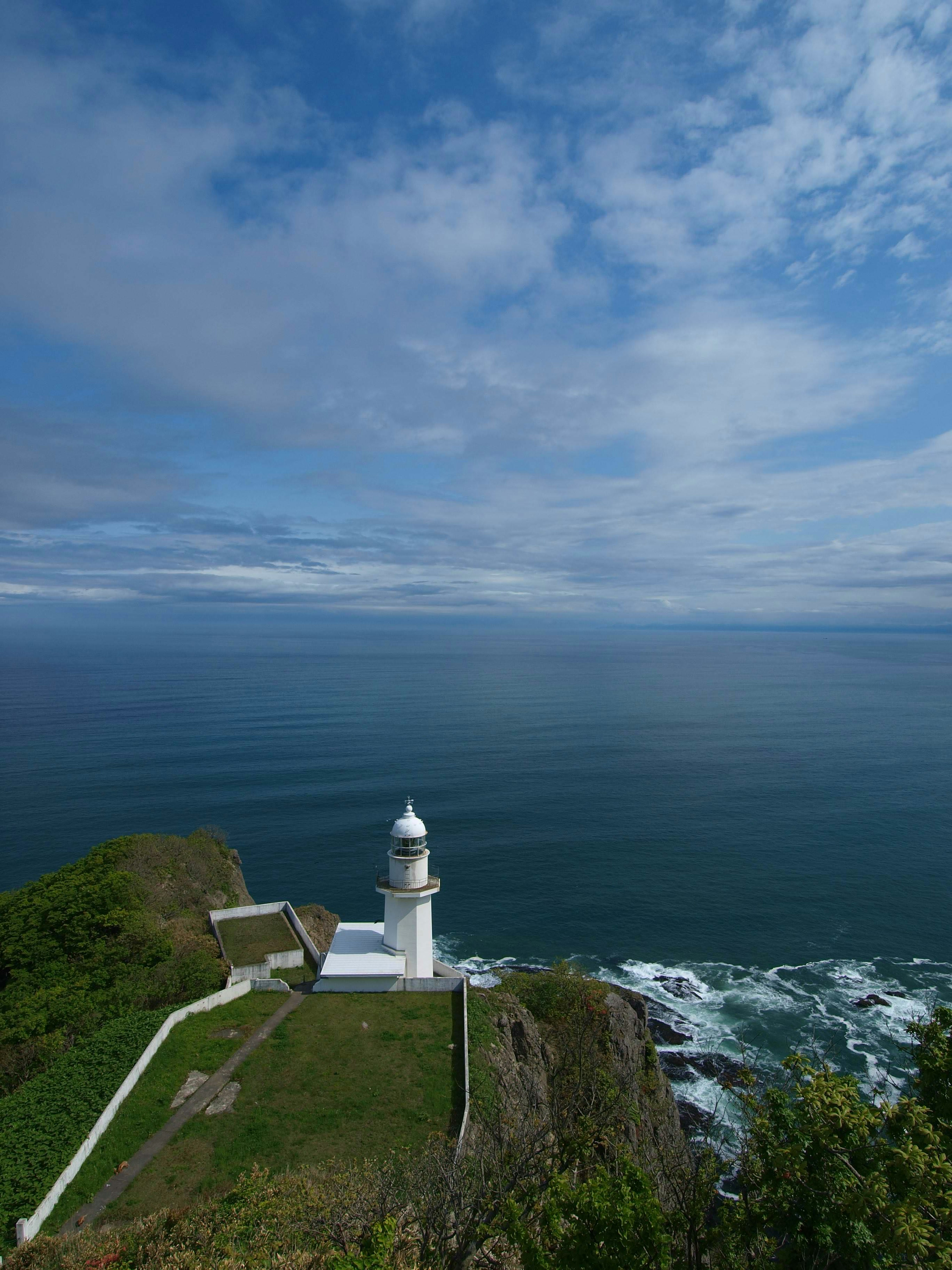 Un phare surplombant la mer avec un beau ciel bleu