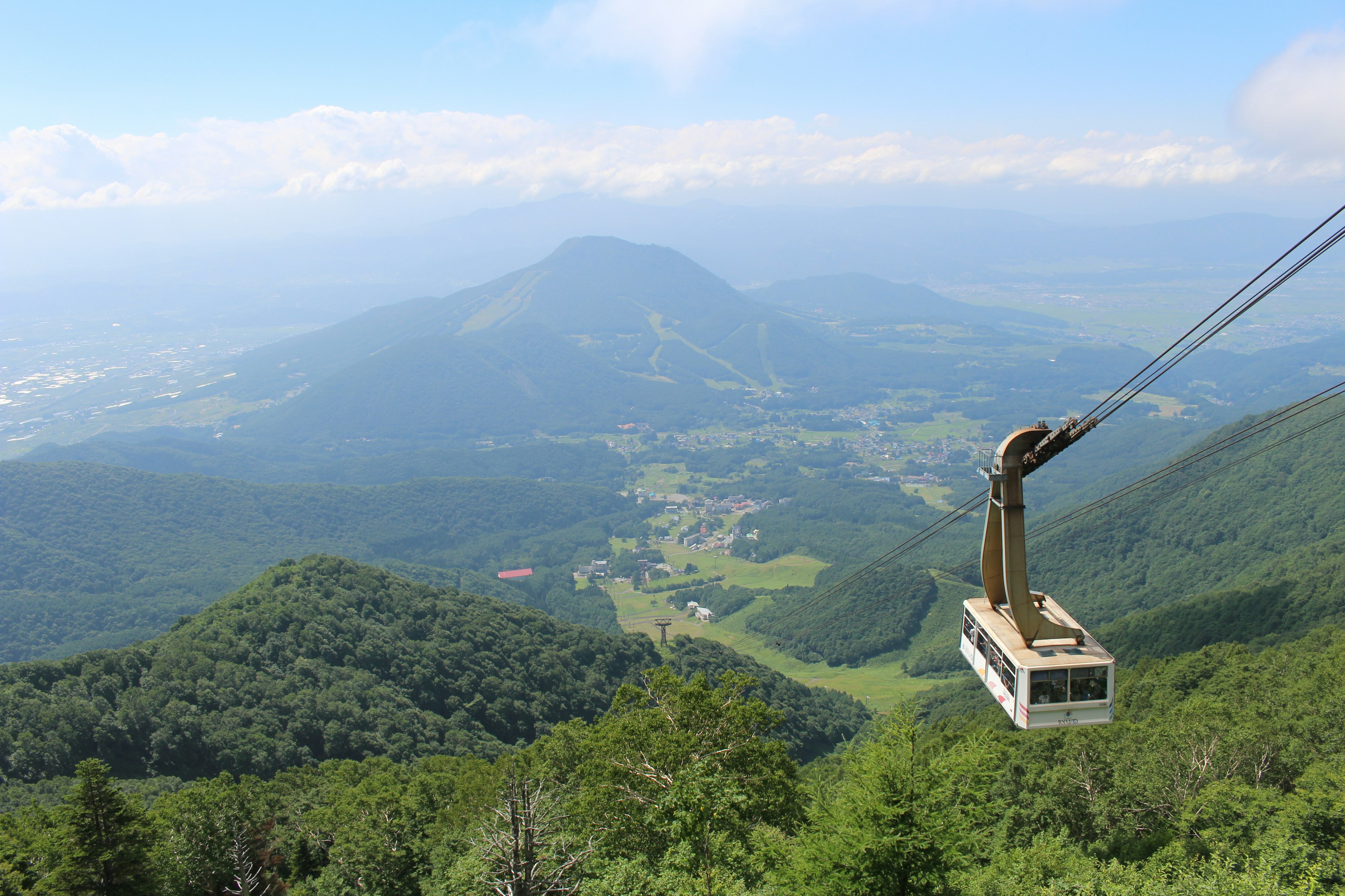 山の上にあるロープウェイが美しい風景を横切る