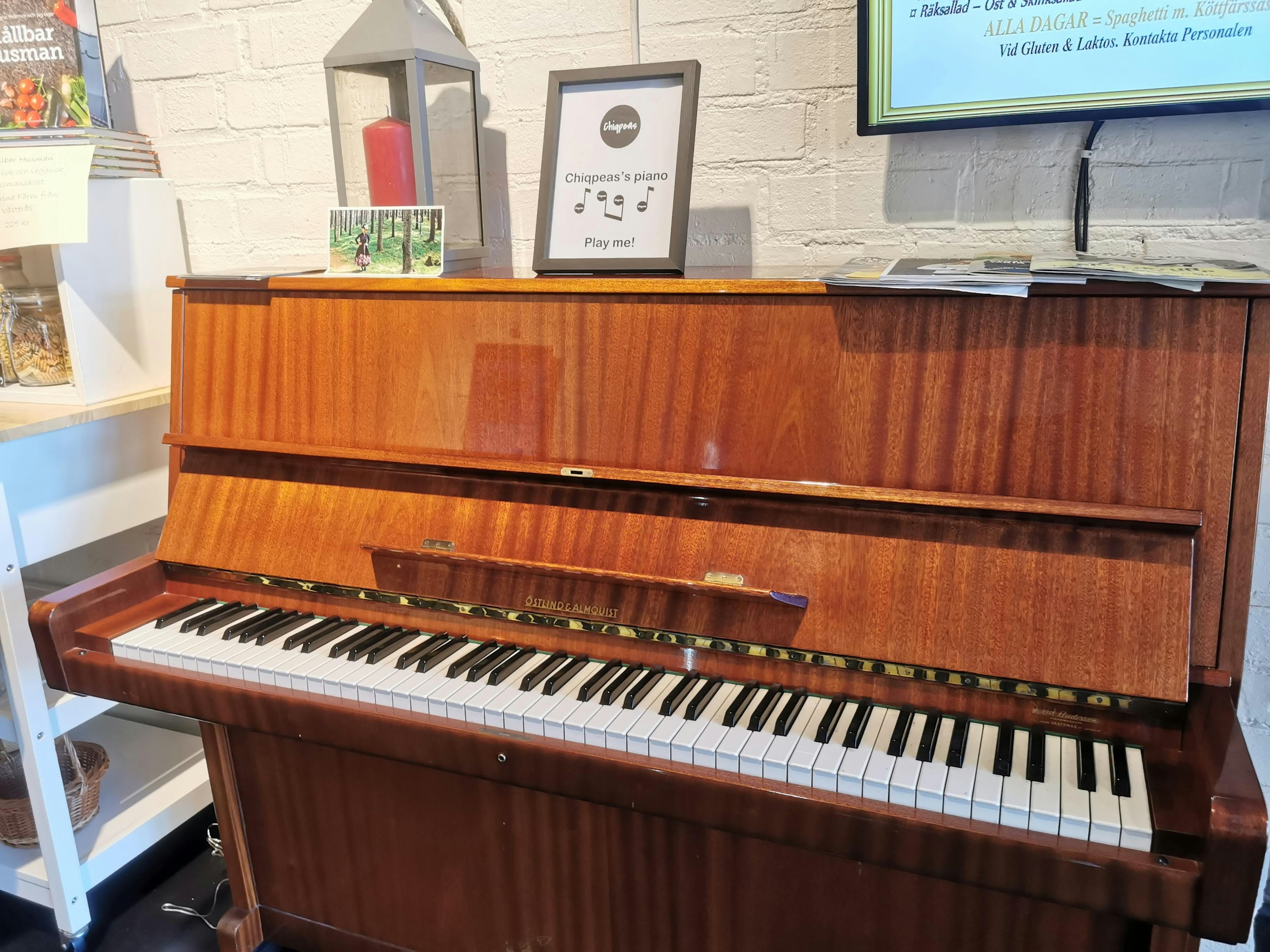 Imagen de un piano de madera en una esquina de una habitación