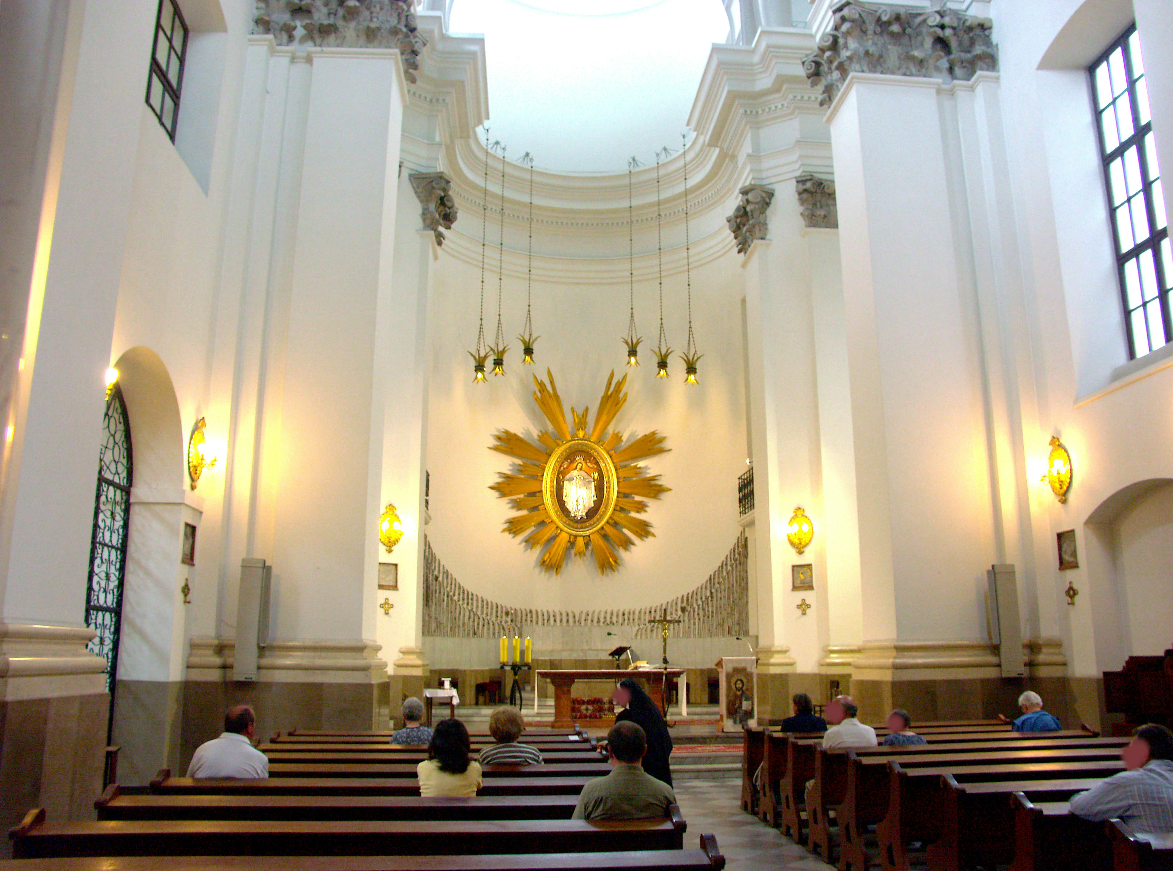 Interior of a church with a golden decorated altar peaceful atmosphere people sitting on wooden benches