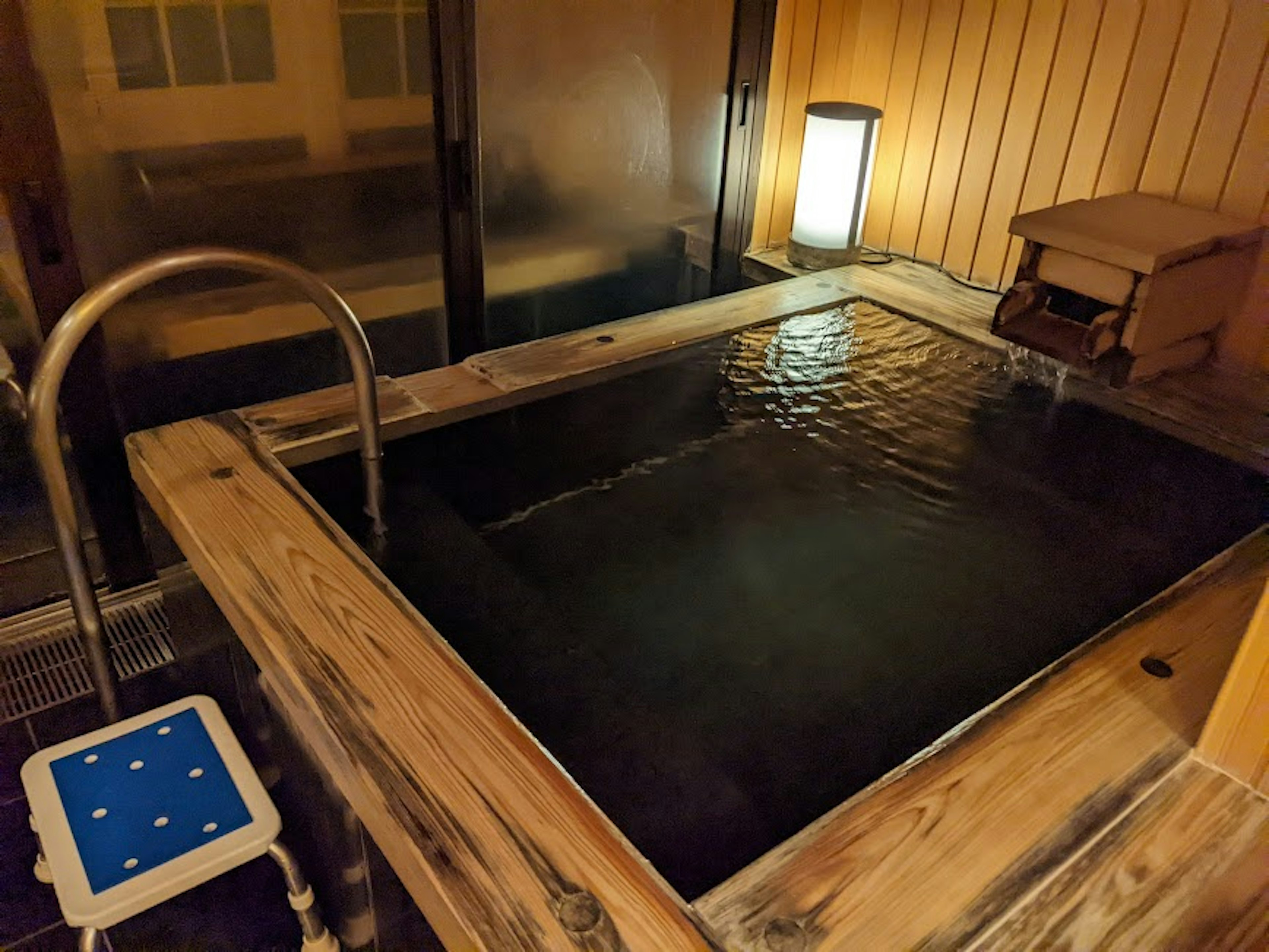 Interior of a hot spring with wooden tub and lamp