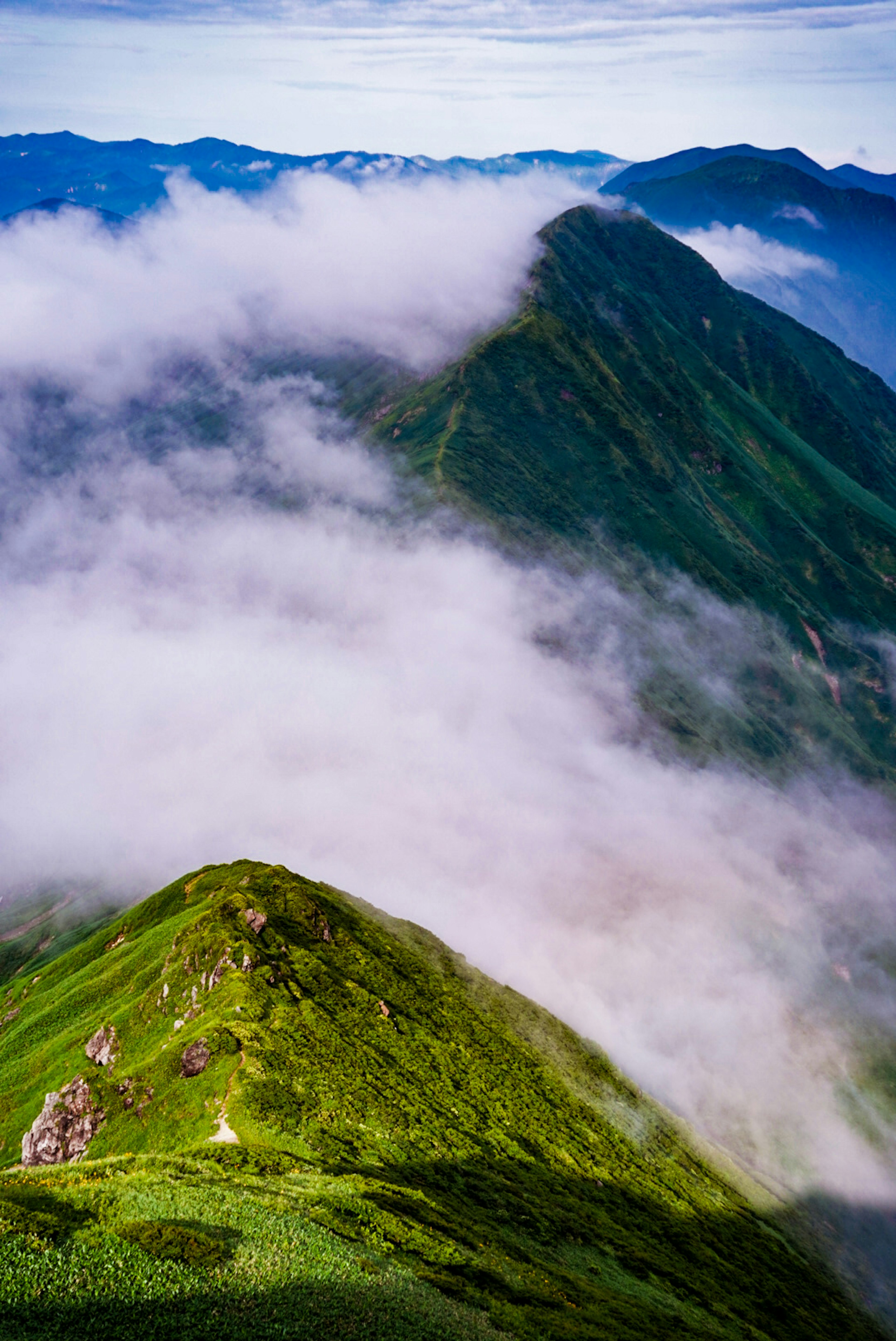 緑の山々と雲に覆われた風景の上空からの眺め