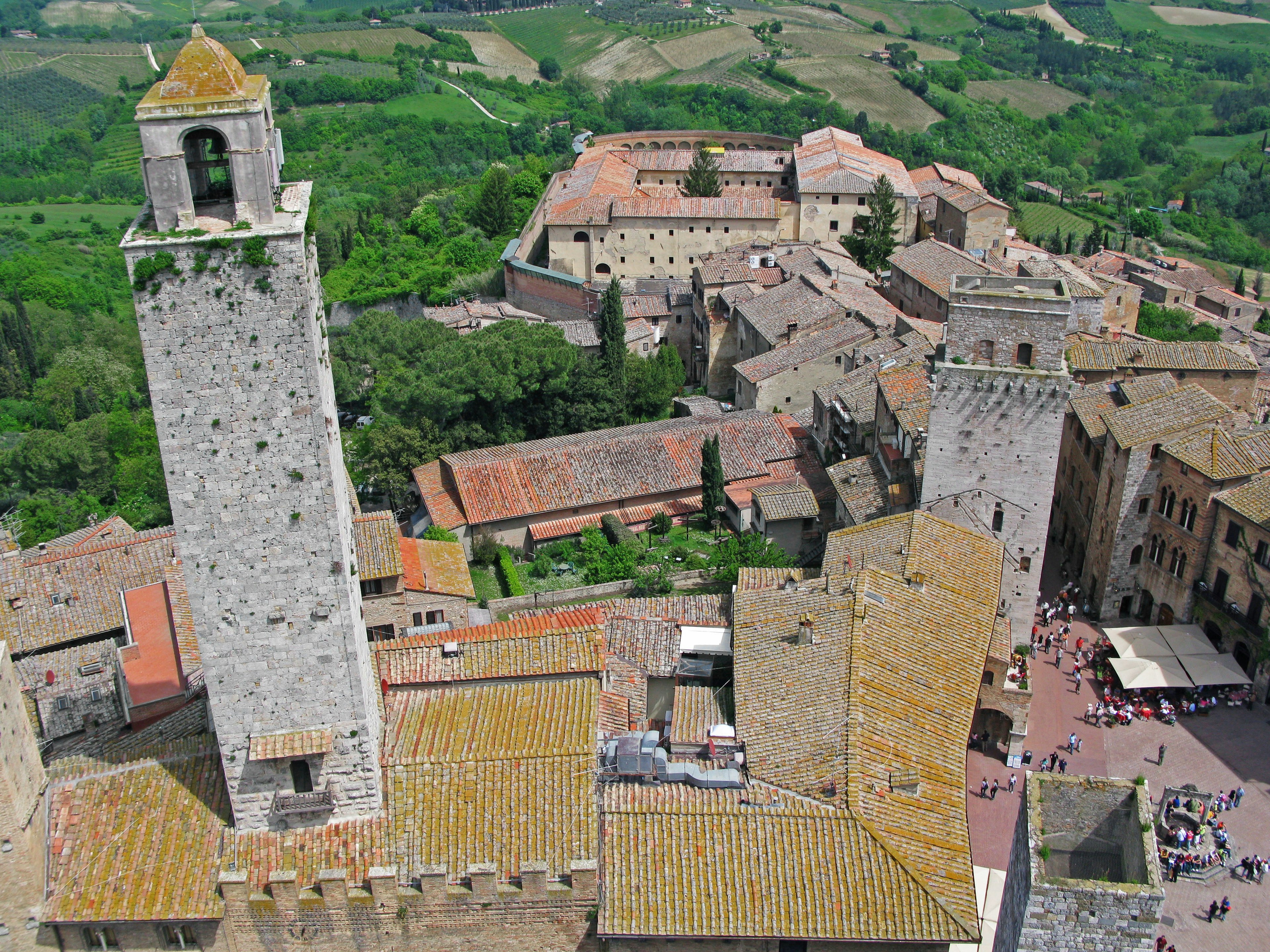 Vista aerea di un villaggio medievale con torri di pietra e tetti in terracotta