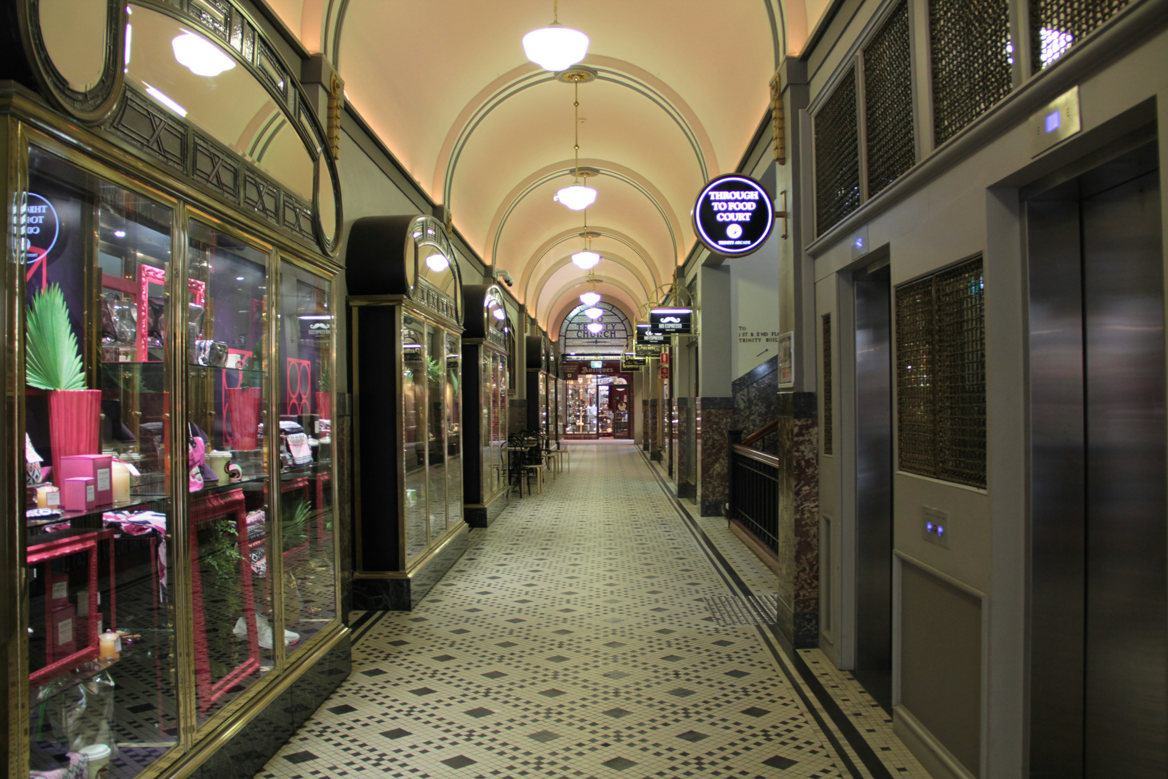 Hermoso corredor de arcade con vitrinas de tiendas y ascensores