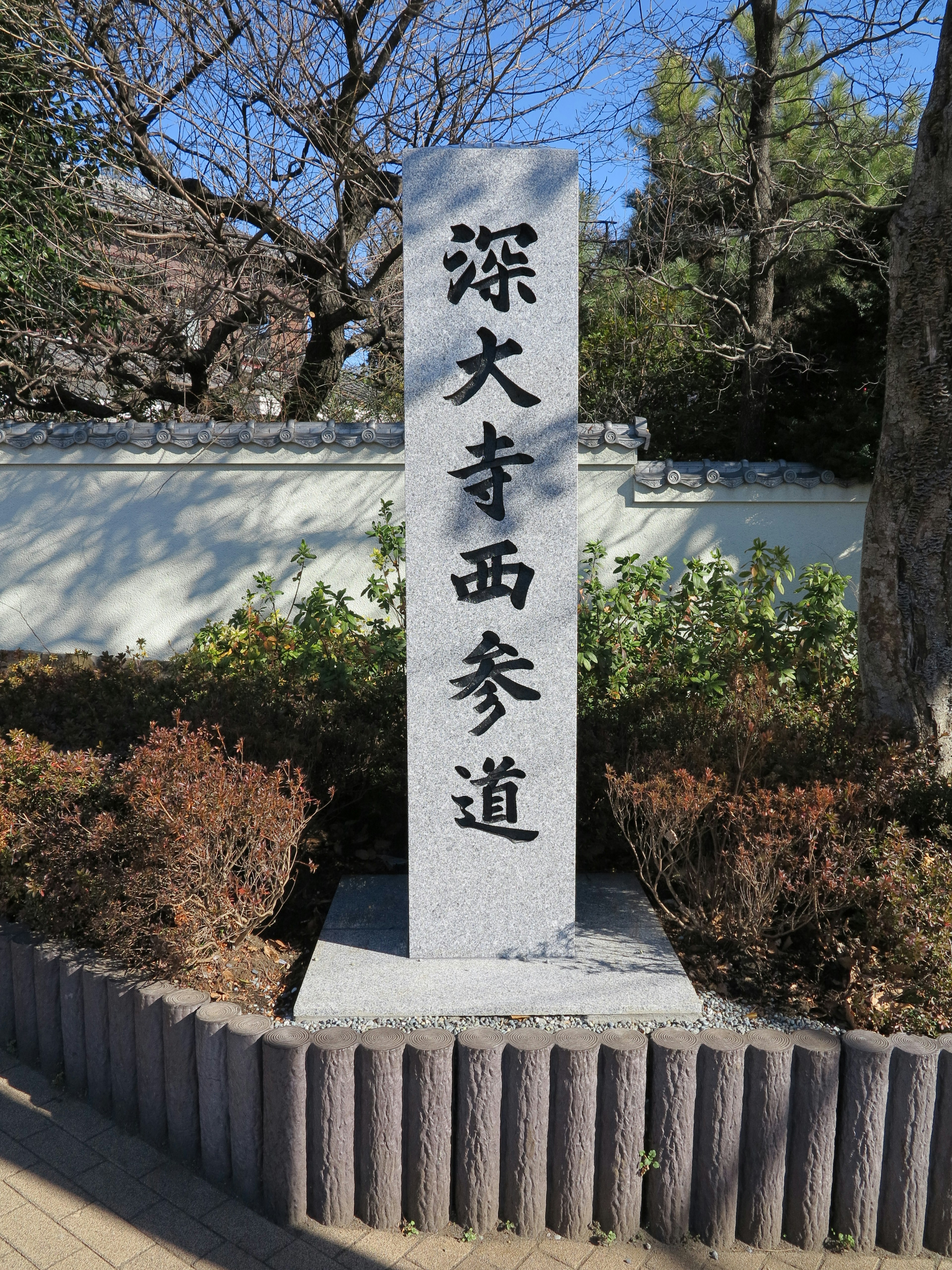 Monument en pierre de l'Approche Ouest de Jindaiji entouré de verdure