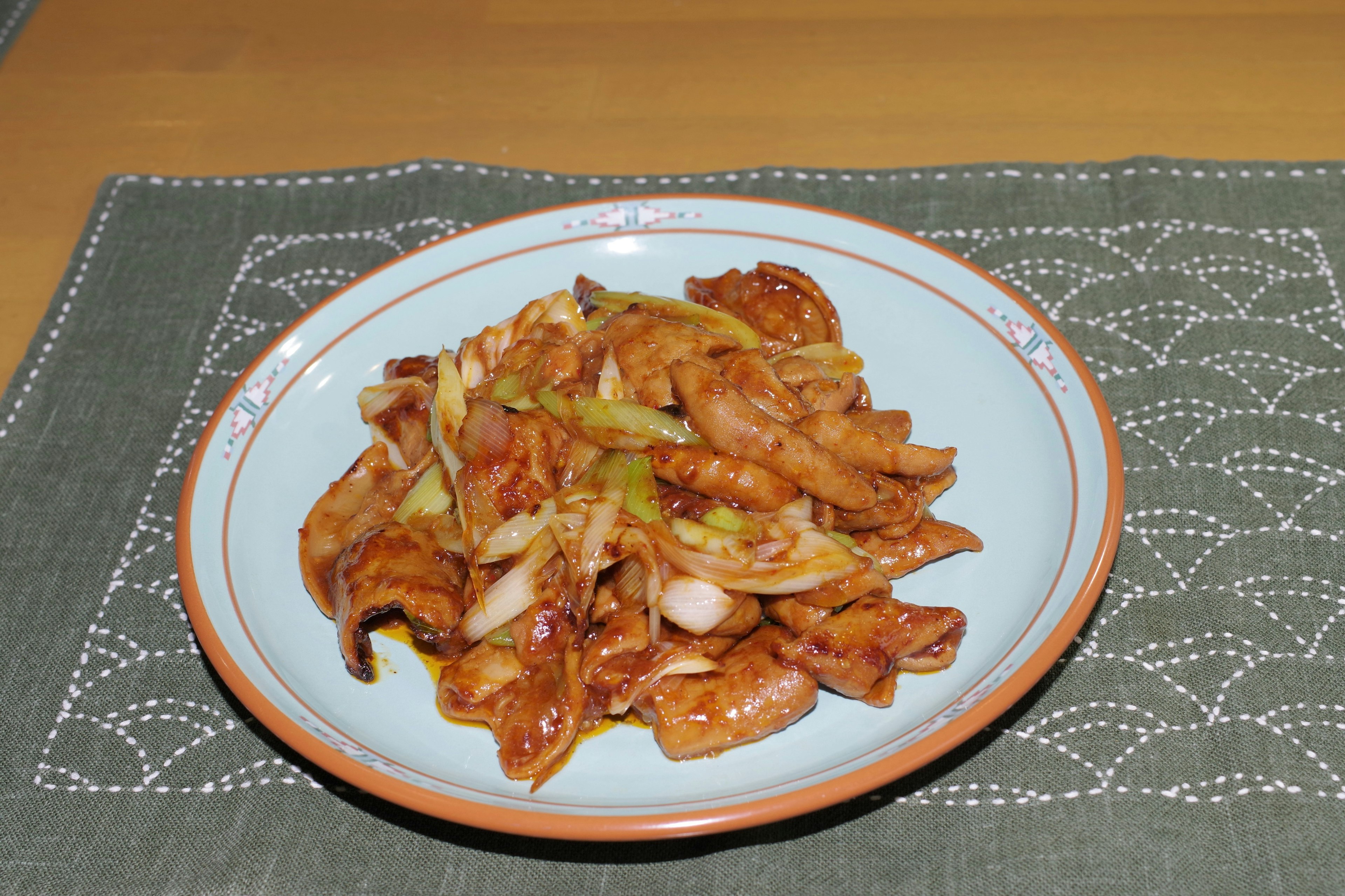 Stir-fried chicken and vegetables served on a blue plate