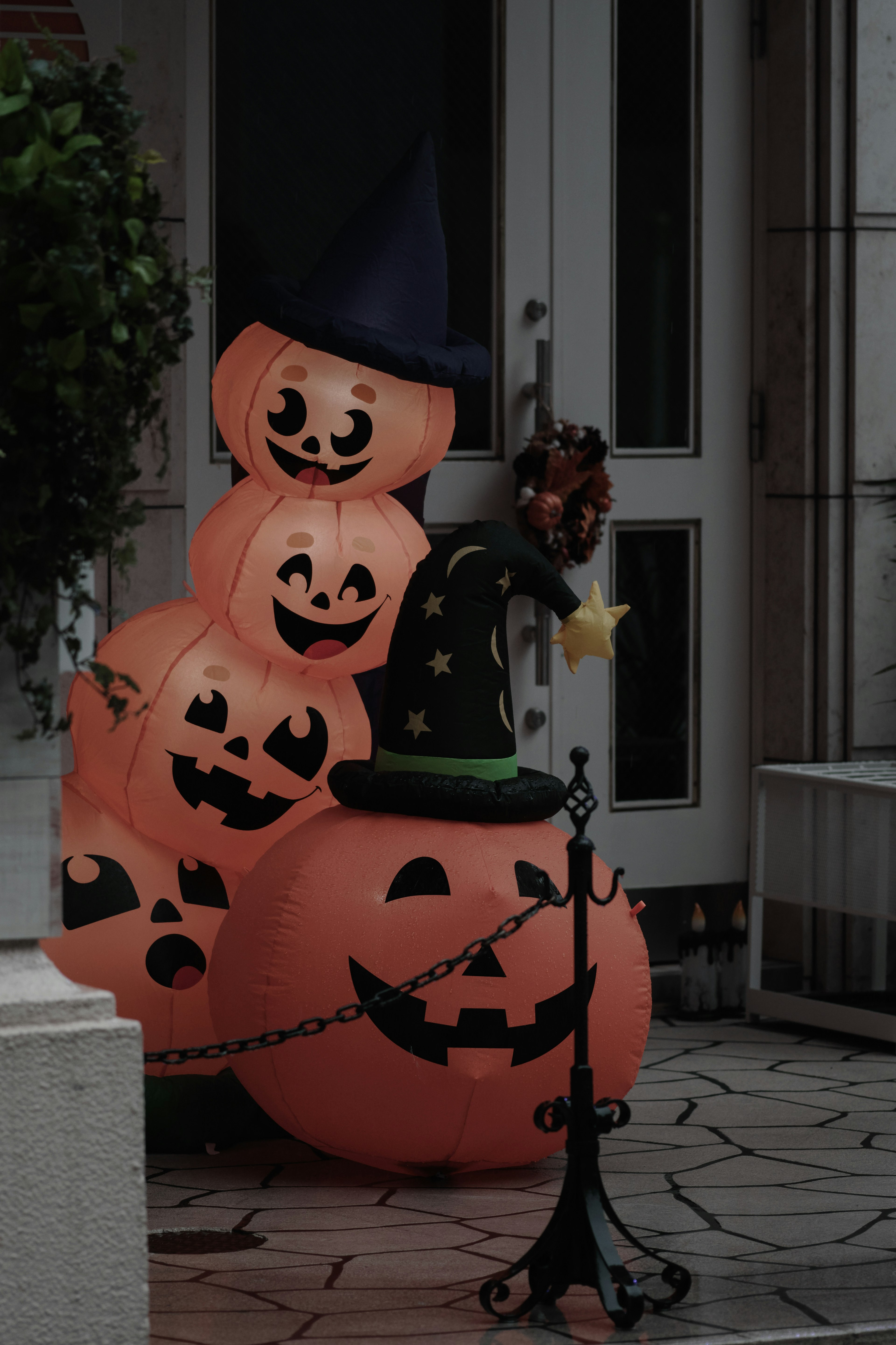 Halloween decorations featuring stacked jack-o'-lanterns with a witch hat