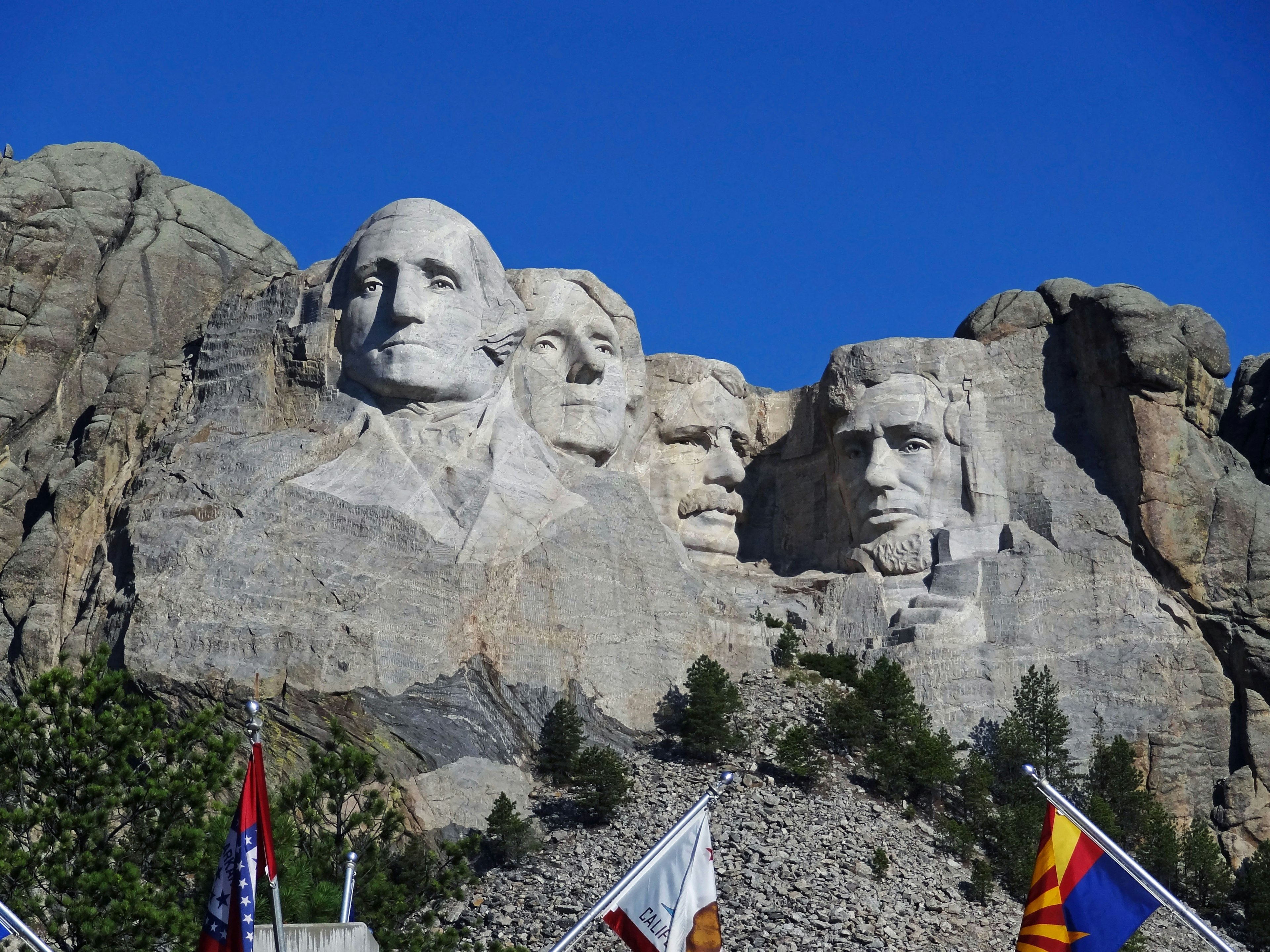 Monte Rushmore con las caras esculpidas de cuatro presidentes estadounidenses bajo un cielo azul claro