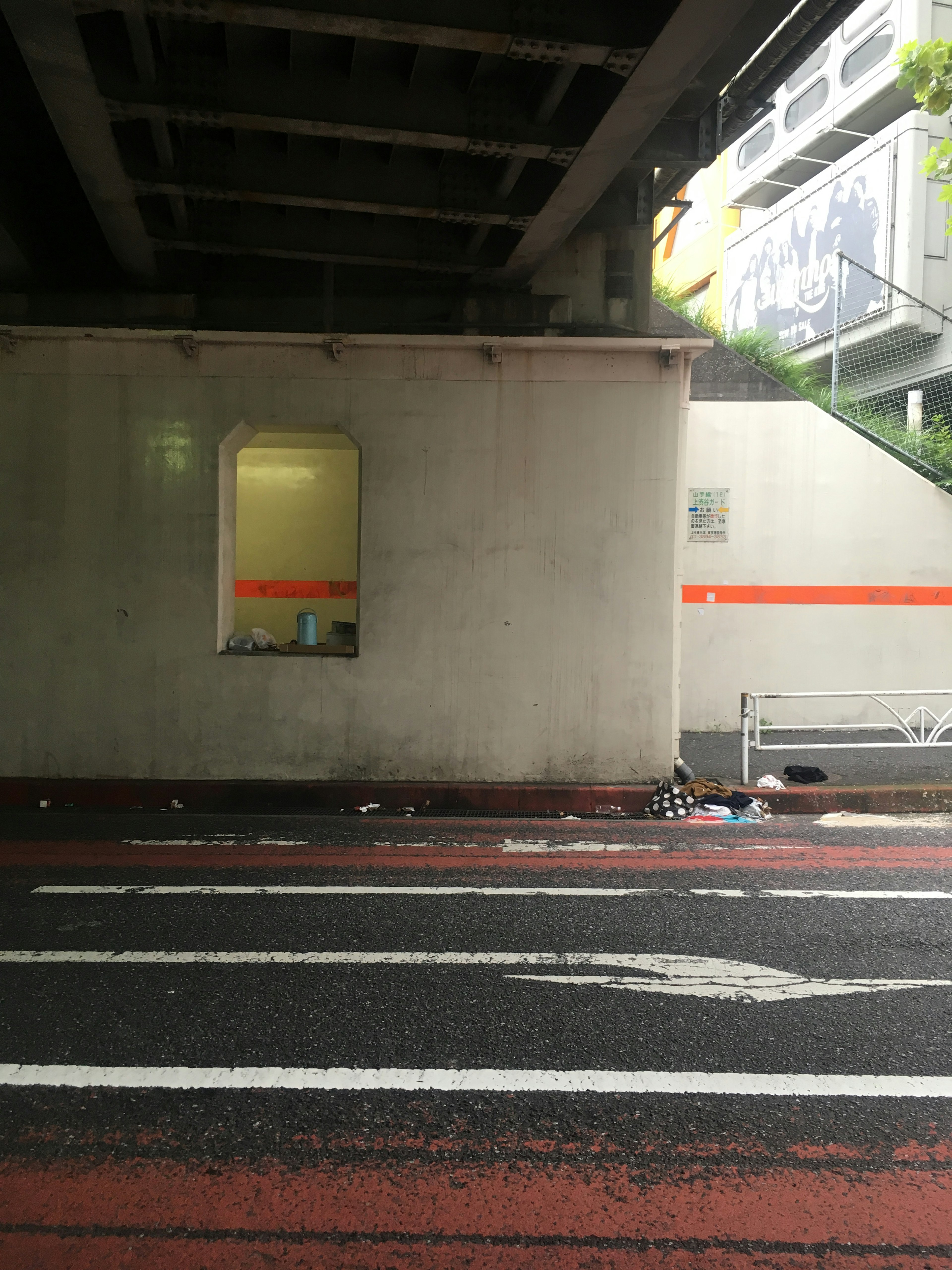 Urban scene featuring a wall and window under an overpass